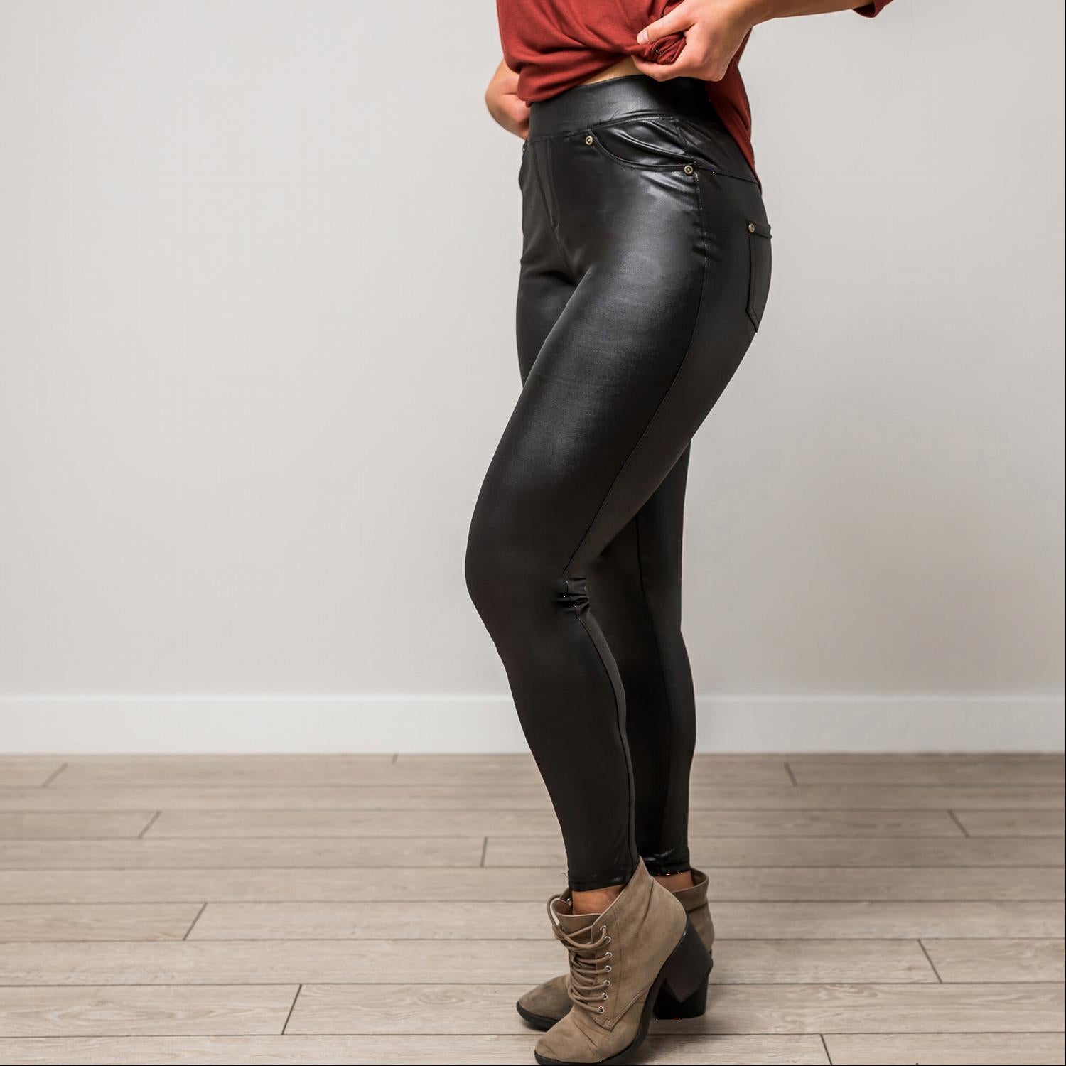 A pair of stylish black faux leather leggings displayed on a white background, showcasing their sleek design and stretchy fabric.