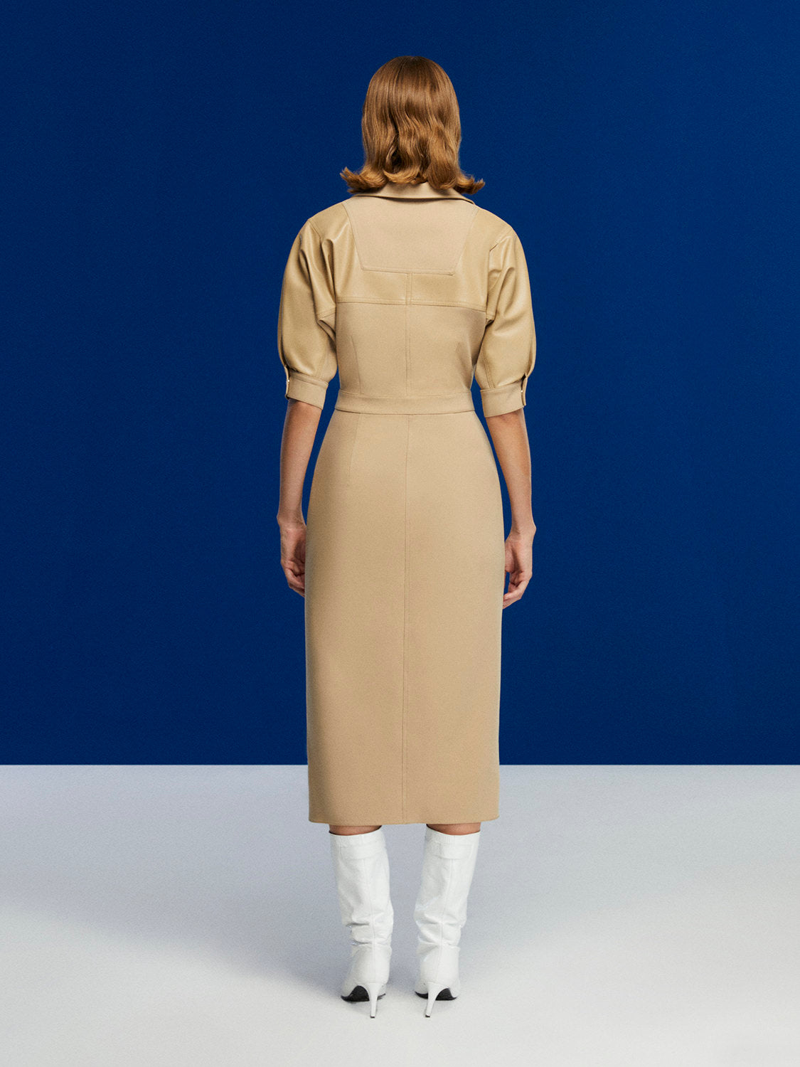 A stylish pleated midi dress featuring faux leather trimming, below-the-elbow sleeves, and a front metal snap button closure.