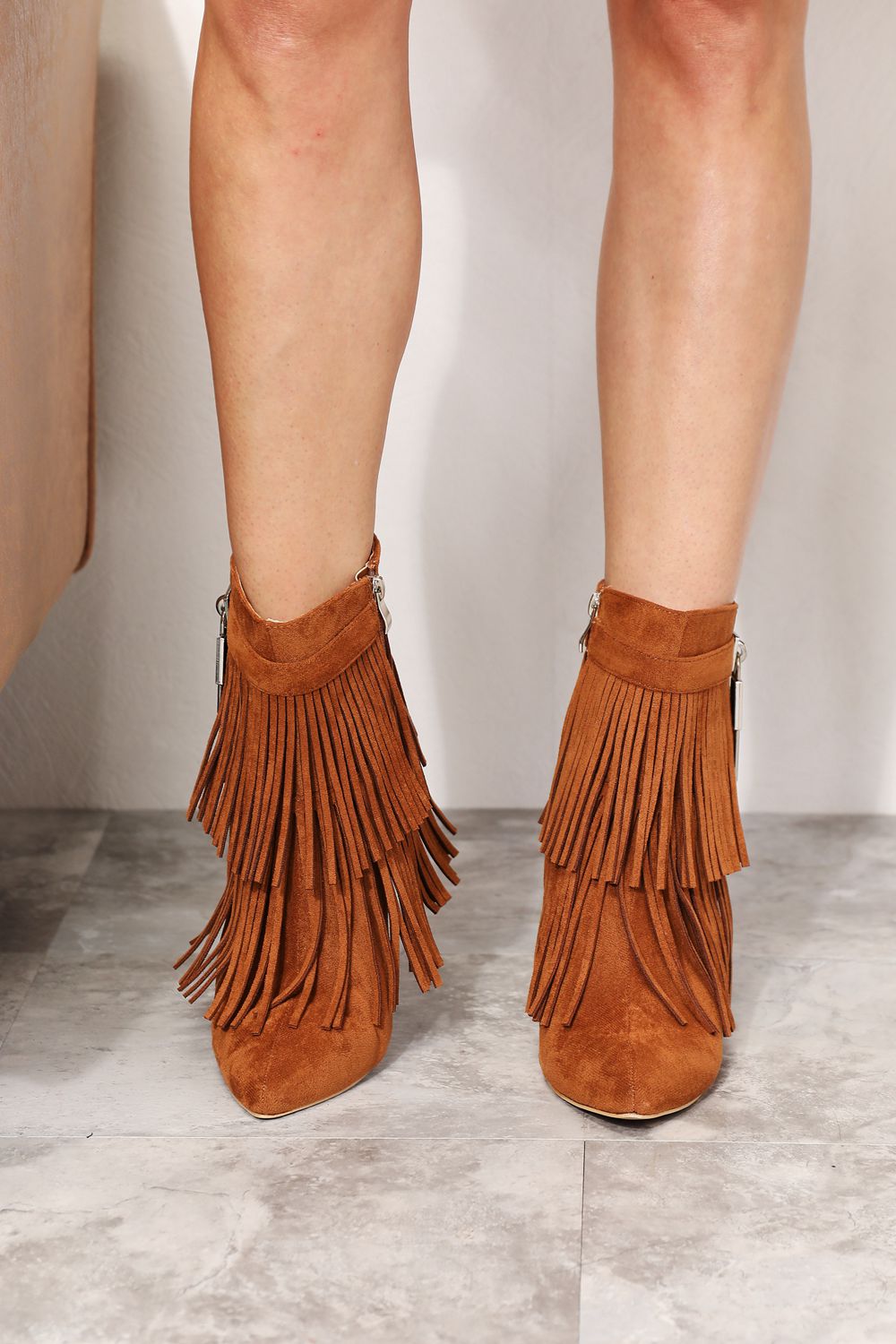 Legend Women's Tassel Wedge Heel Ankle Booties featuring an open shank design, pointy toe, and stylish tassels in premium vegan suede.