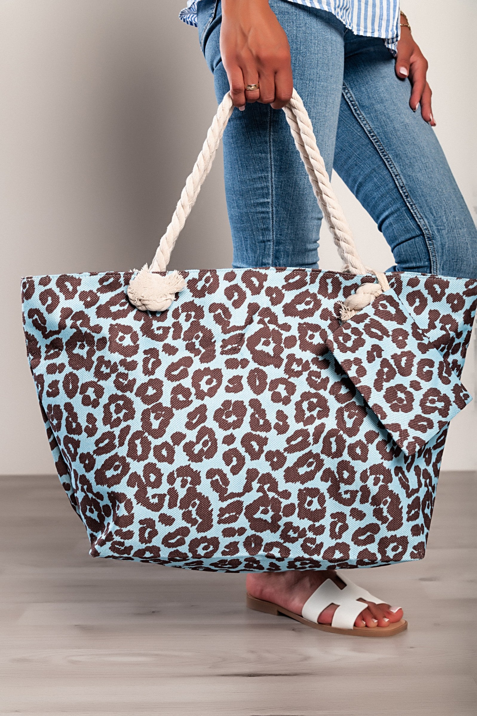 Light blue leopard print beach bag with braided handles and zip closure, featuring an inside pocket and a small matching bag.