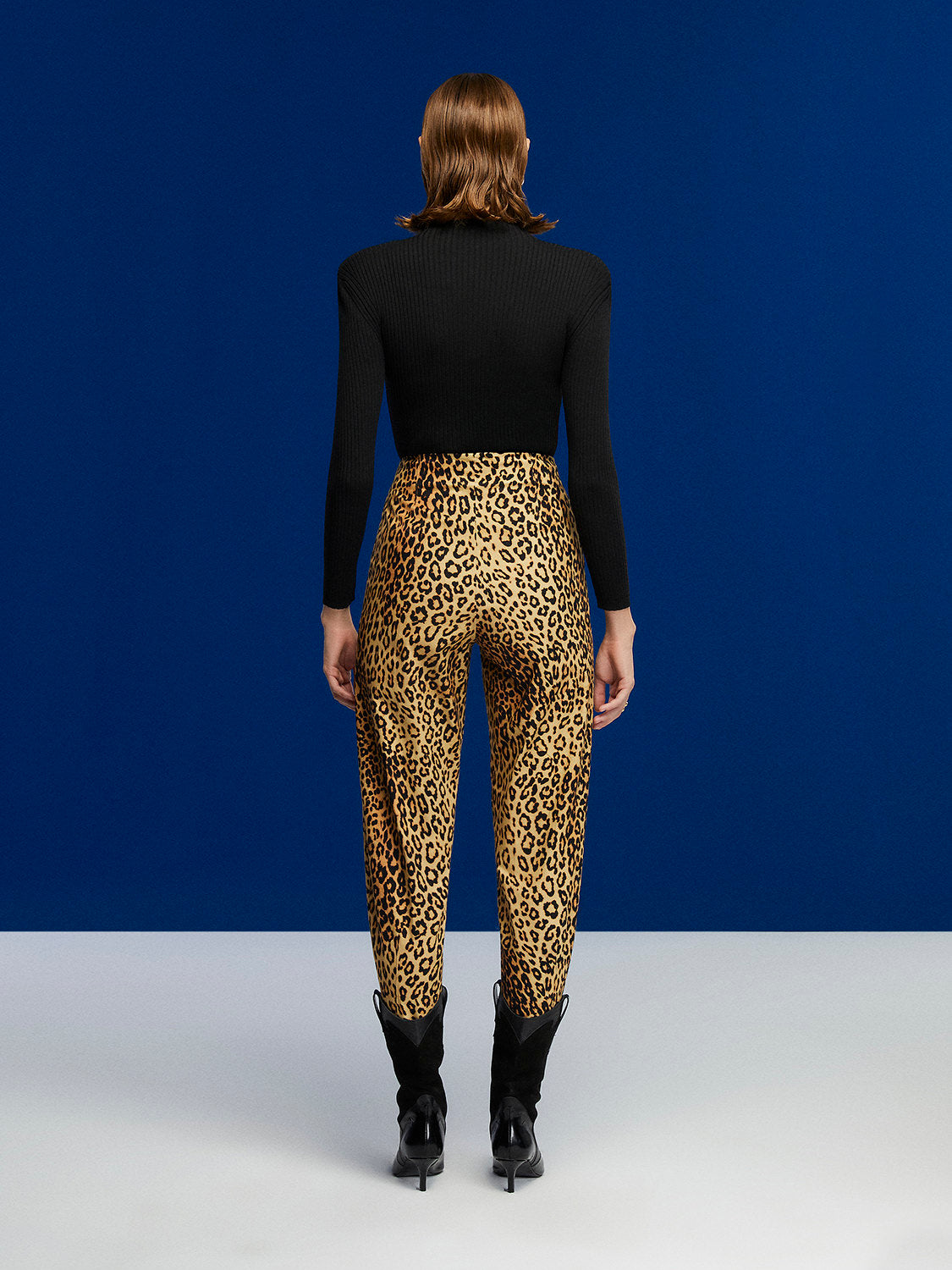 A pair of high-waisted leopard print slouchy pants with side pockets and pleat details, showcasing a trendy and stylish design.