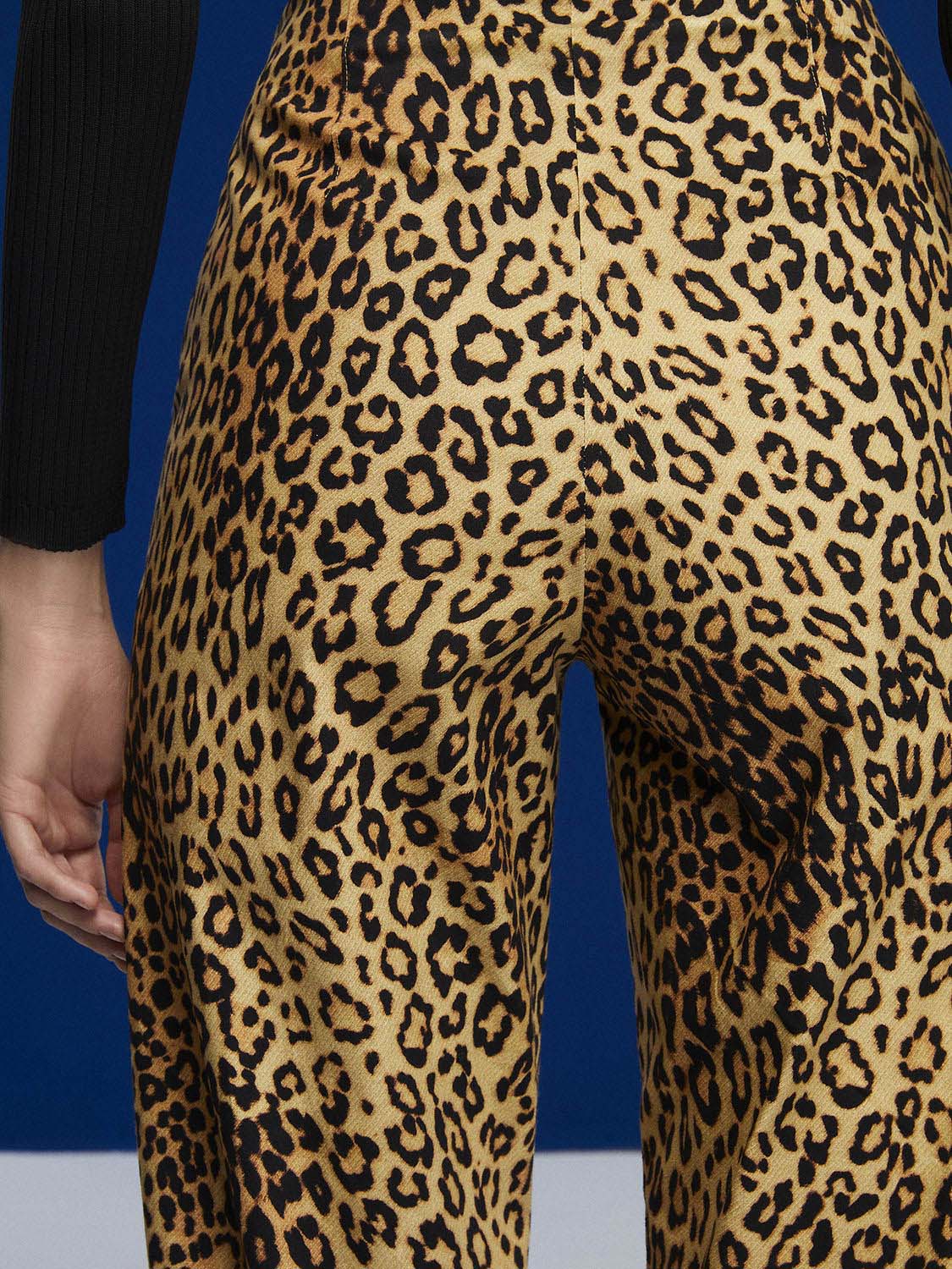 A pair of high-waisted leopard print slouchy pants with side pockets and pleat details, showcasing a trendy and stylish design.