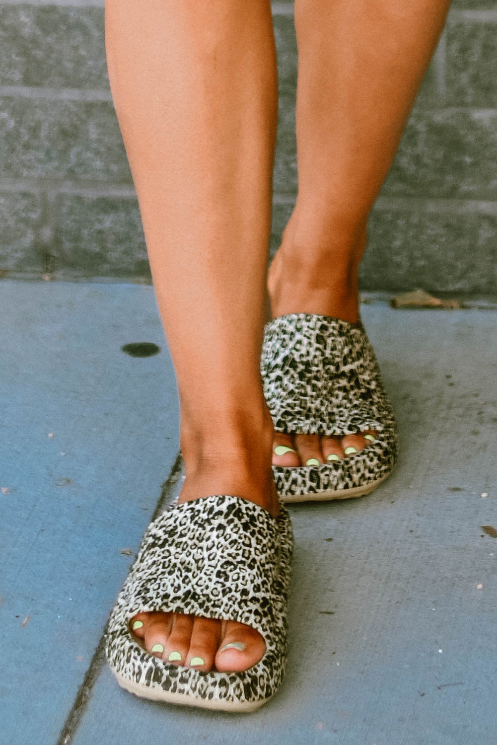 A pair of stylish leopard print soft rubber slippers designed for women, featuring a breathable hollow side and thick sole for comfort.