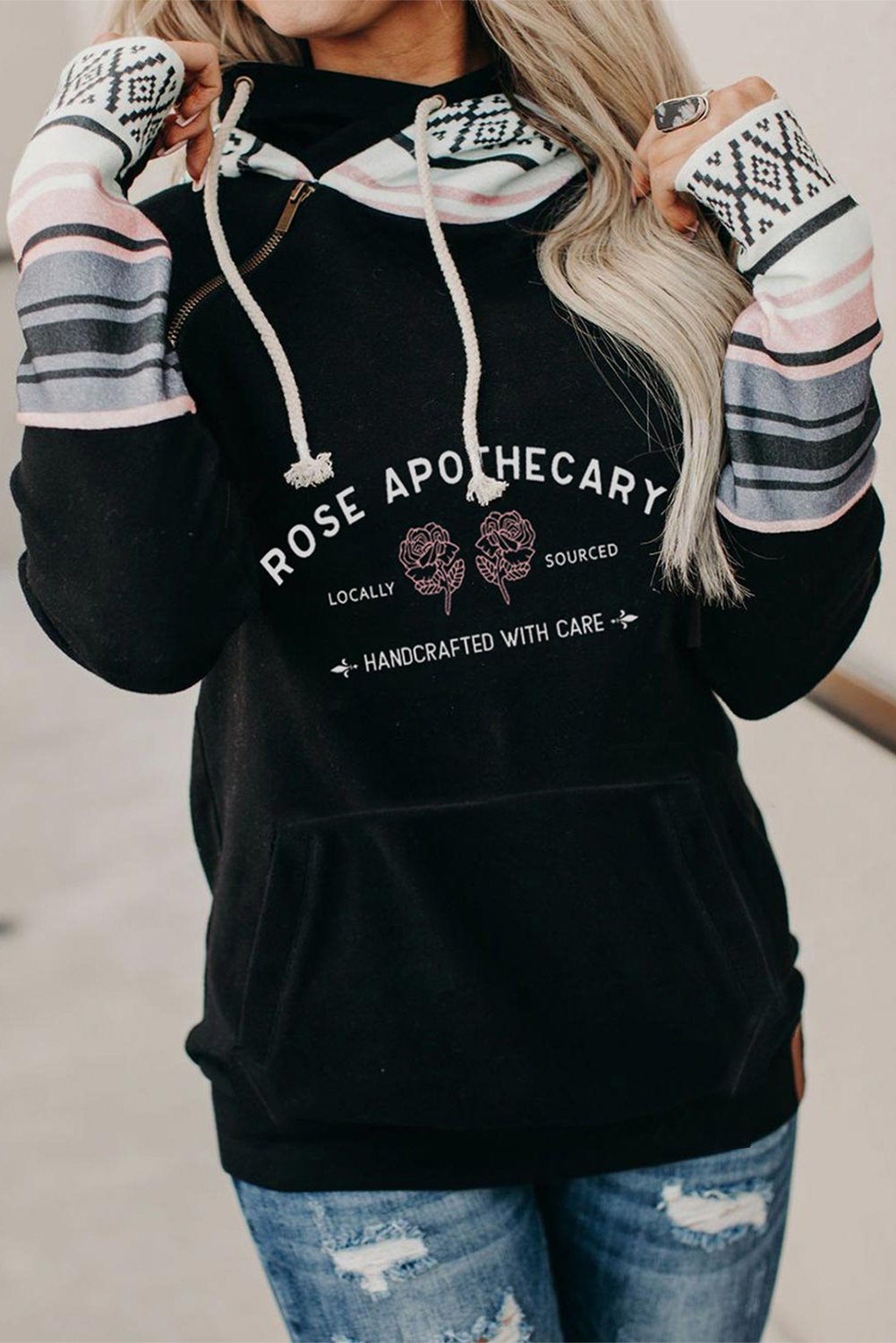 A stylish black hoodie featuring rose and letter prints with colorful striped cuffs and an inclined zipper detail, perfect for casual wear.