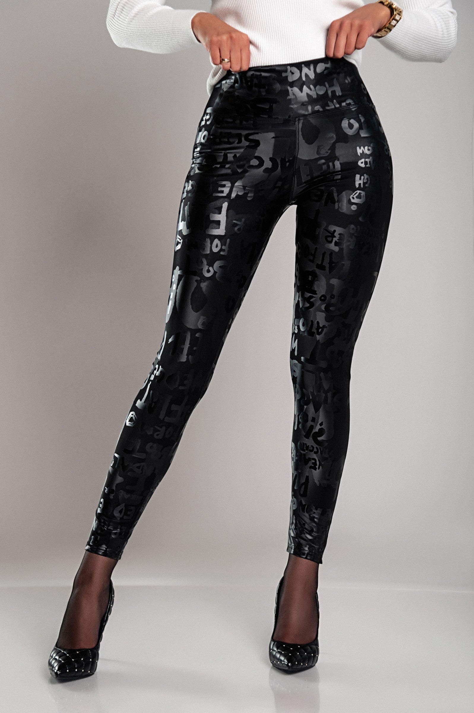 Black lined leggings with a wide waistband and fashionable letter print design, showcasing their soft and elastic fabric.