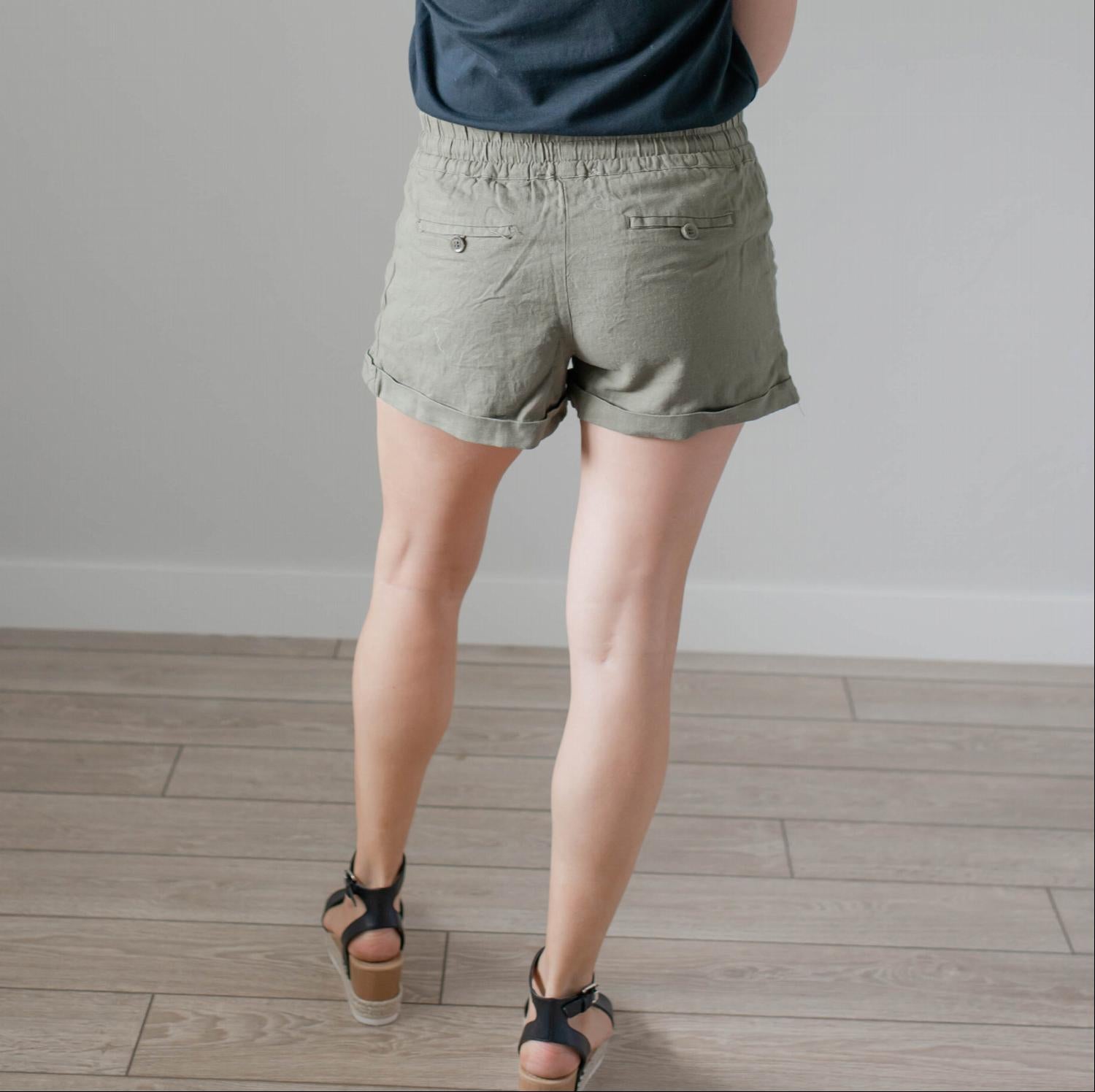 A pair of stylish linen shorts with pockets, featuring a tie front and adjustable waist, perfect for summer wear.