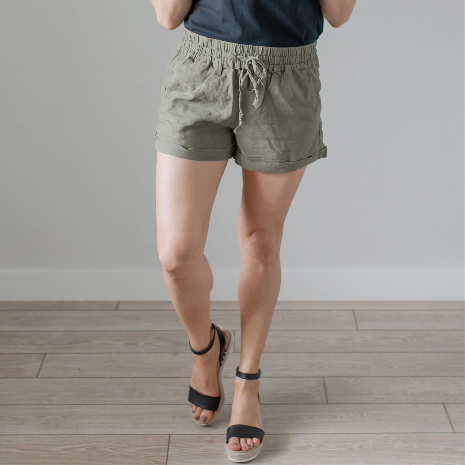 A pair of stylish linen shorts with pockets, featuring a tie front and adjustable waist, perfect for summer wear.