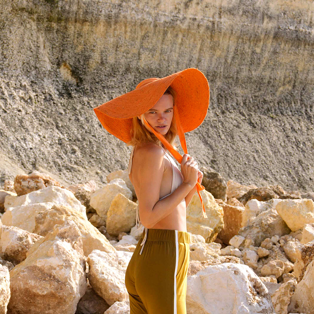 LOLA Wide Brim Jute Straw Hat in vibrant orange, showcasing a wide brim and natural jute material, perfect for summer outings.