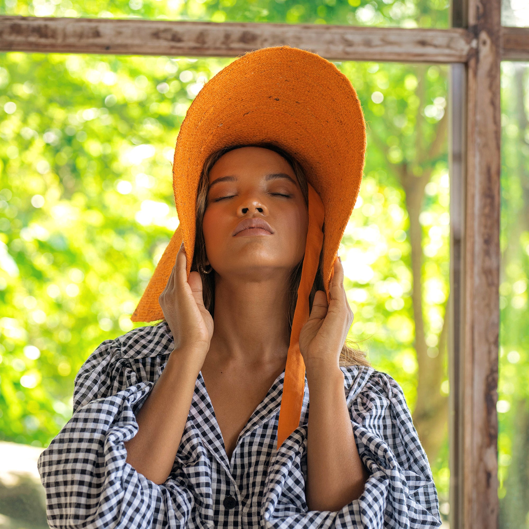 LOLA Wide Brim Jute Straw Hat in vibrant orange, showcasing a wide brim and natural jute material, perfect for summer outings.