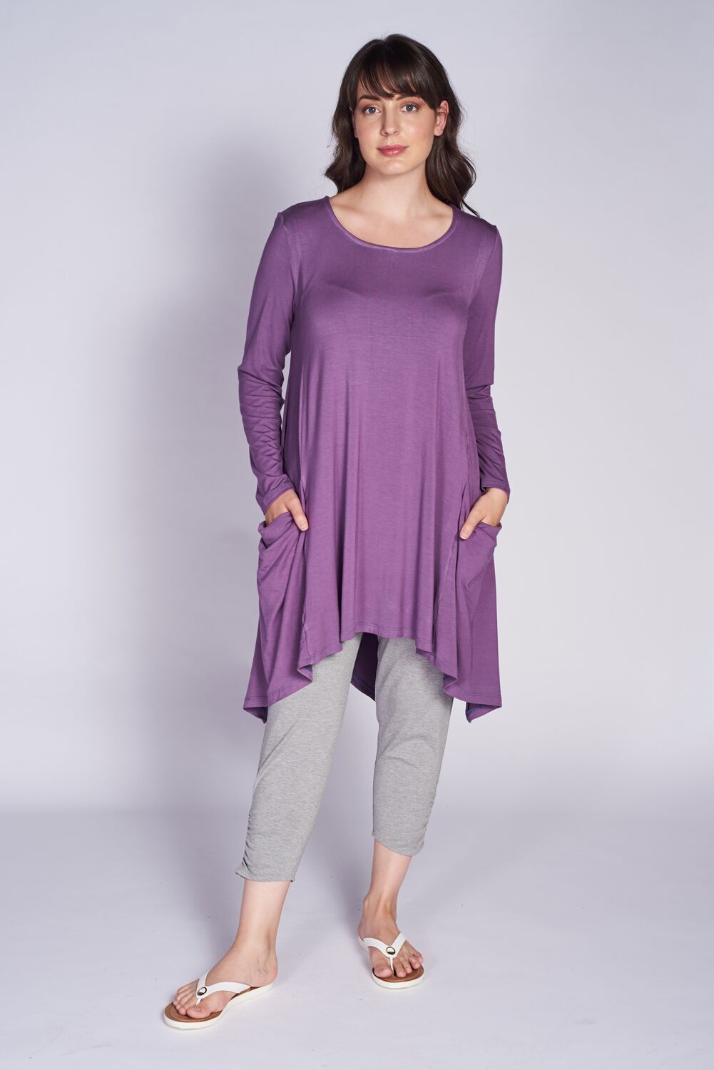 A stylish London Pocket Tunic made from soft bamboo fabric, featuring a scoop neckline, long sleeves, and front pockets with a vented slit at the back.