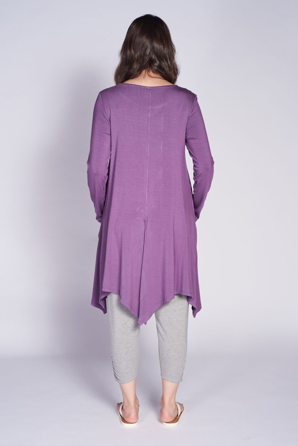 A stylish London Pocket Tunic made from soft bamboo fabric, featuring a scoop neckline, long sleeves, and front pockets with a vented slit at the back.