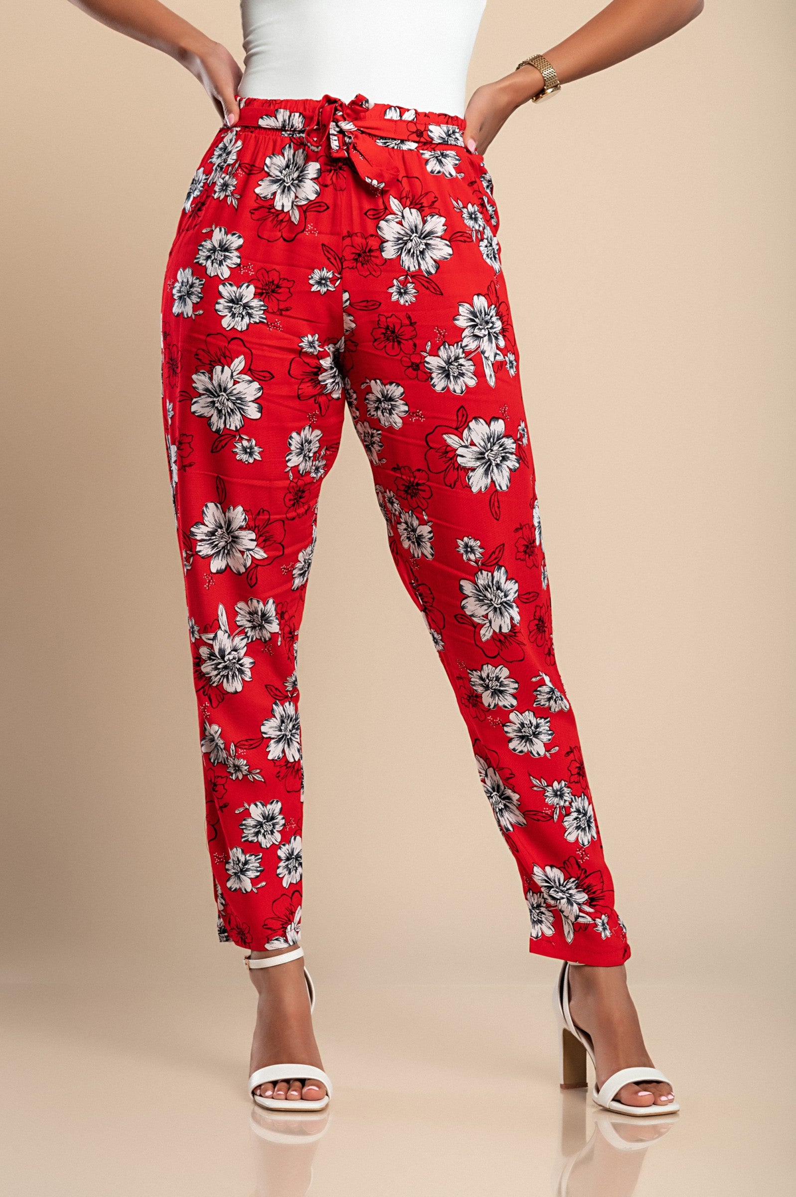 Long red cotton trousers featuring a vibrant floral print, designed for comfort with an elasticated waist and side pockets.