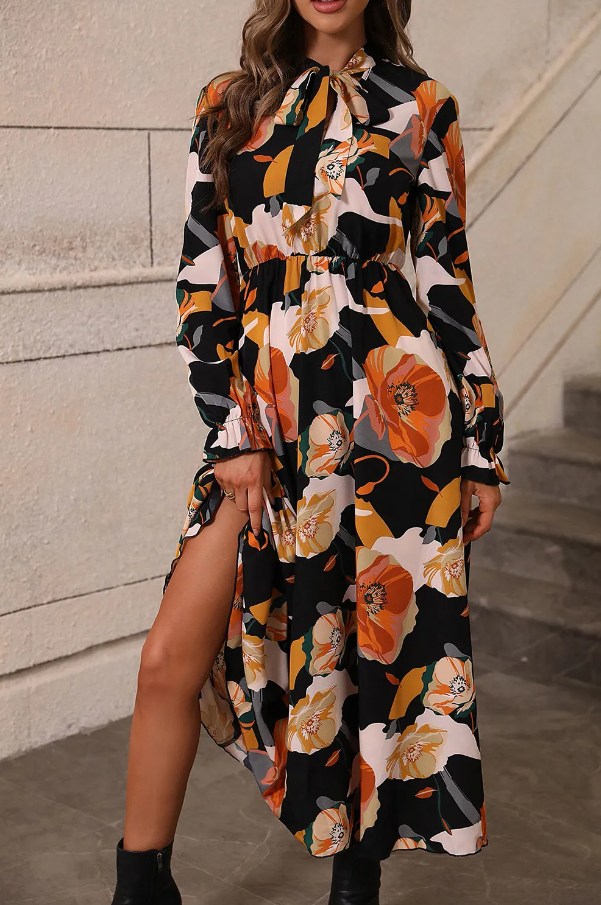 Elegant orange long dress with floral print, featuring long sleeves, a round neckline with a bow, and an elastic waist.