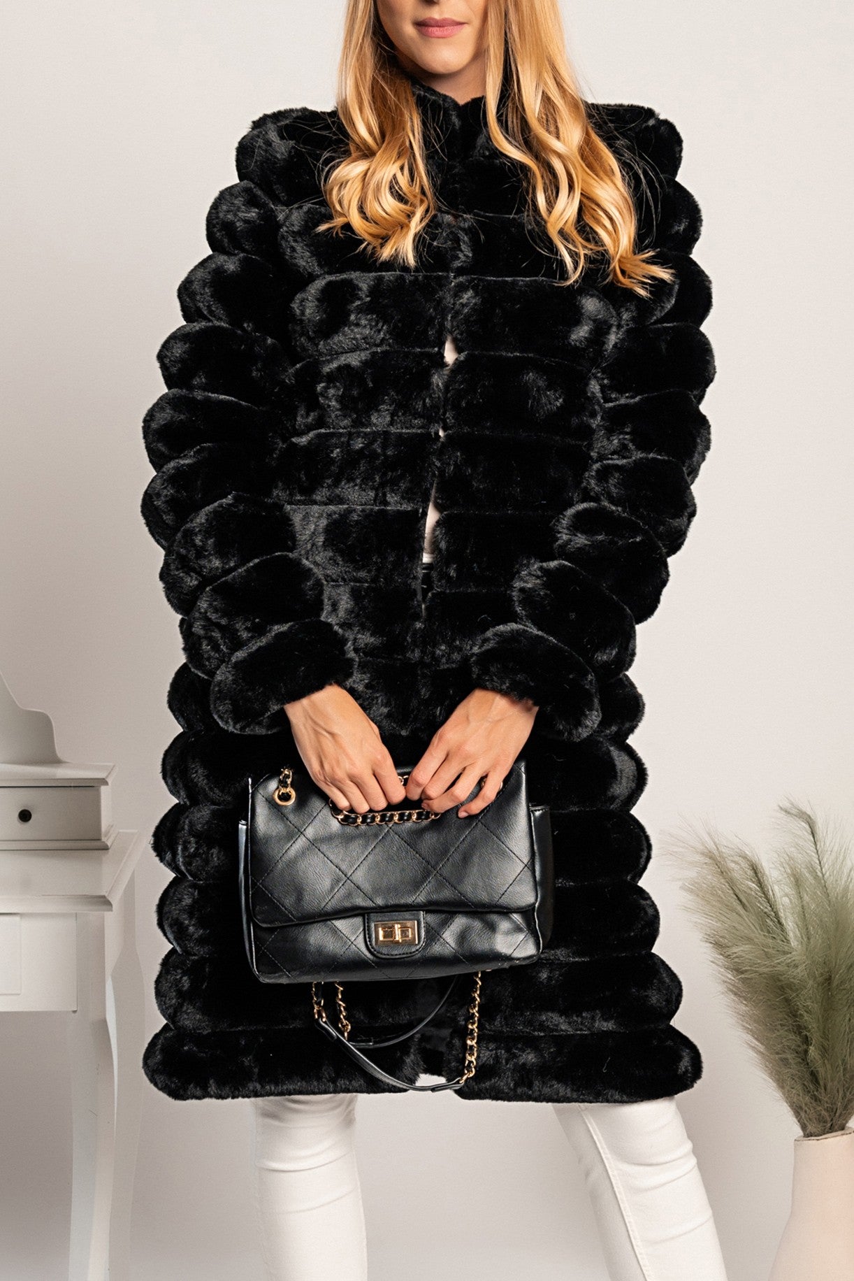 Long elegant black faux fur coat Benimia with stand-up collar and front pockets, showcasing luxurious fabric and stylish design.