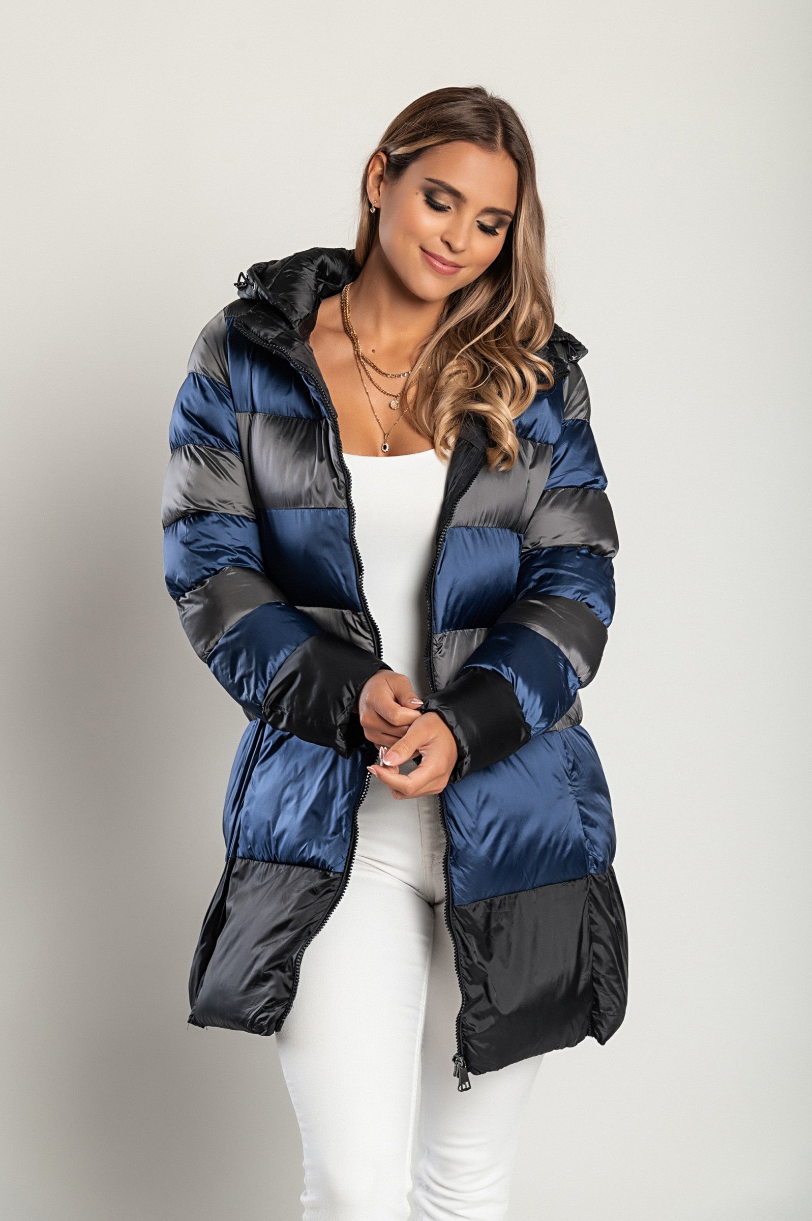 A stylish blue long jacket with a hood and high collar, featuring a zip closure, perfect for winter wear.