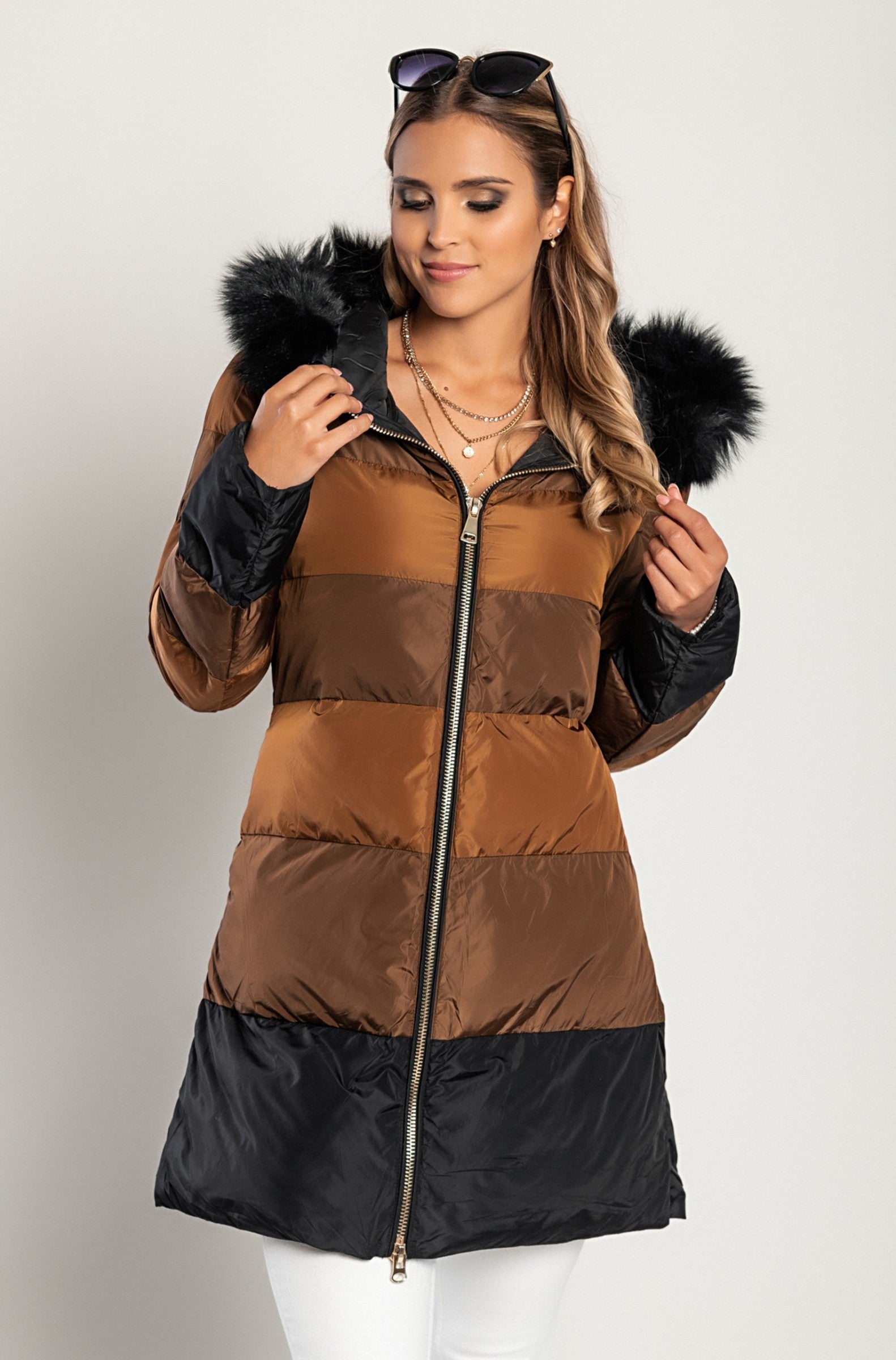 Long camel jacket with hood and faux fur, featuring a high collar and zip closure, perfect for winter wear.