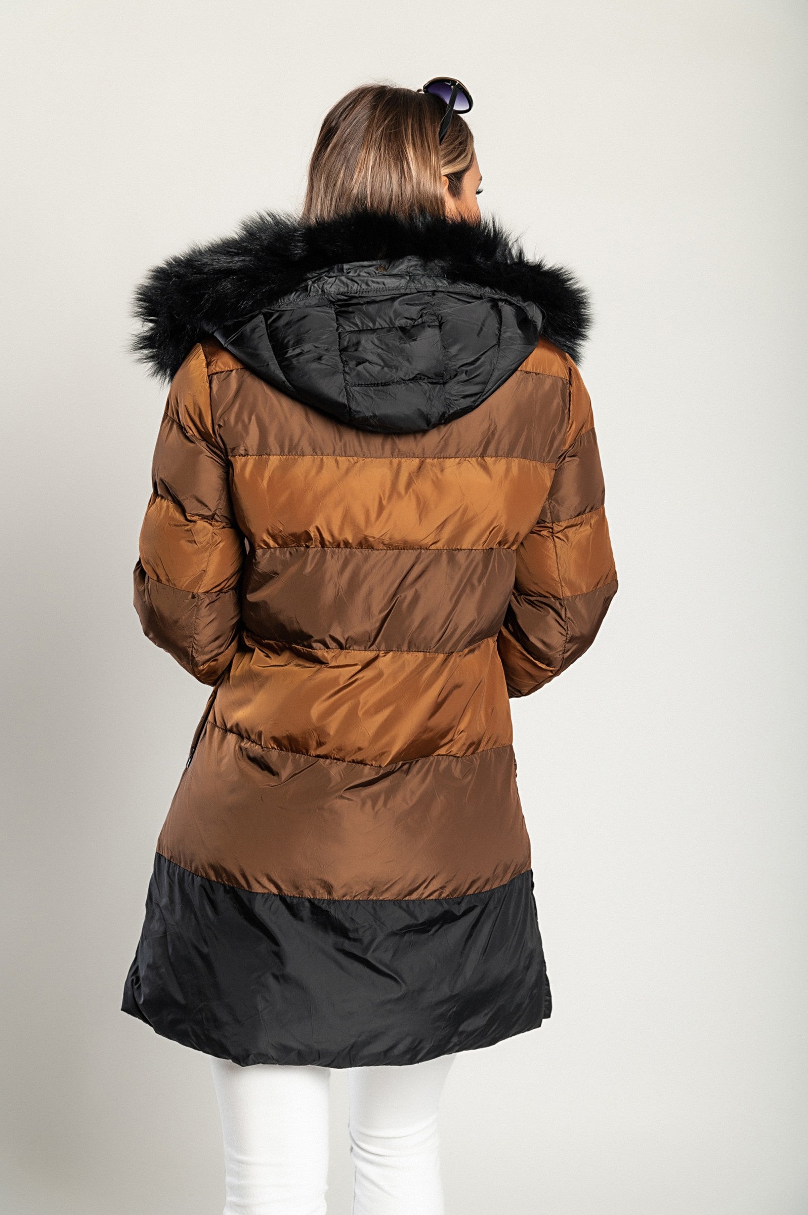 Long camel jacket with hood featuring faux fur trim and zip closure, designed for warmth and style.