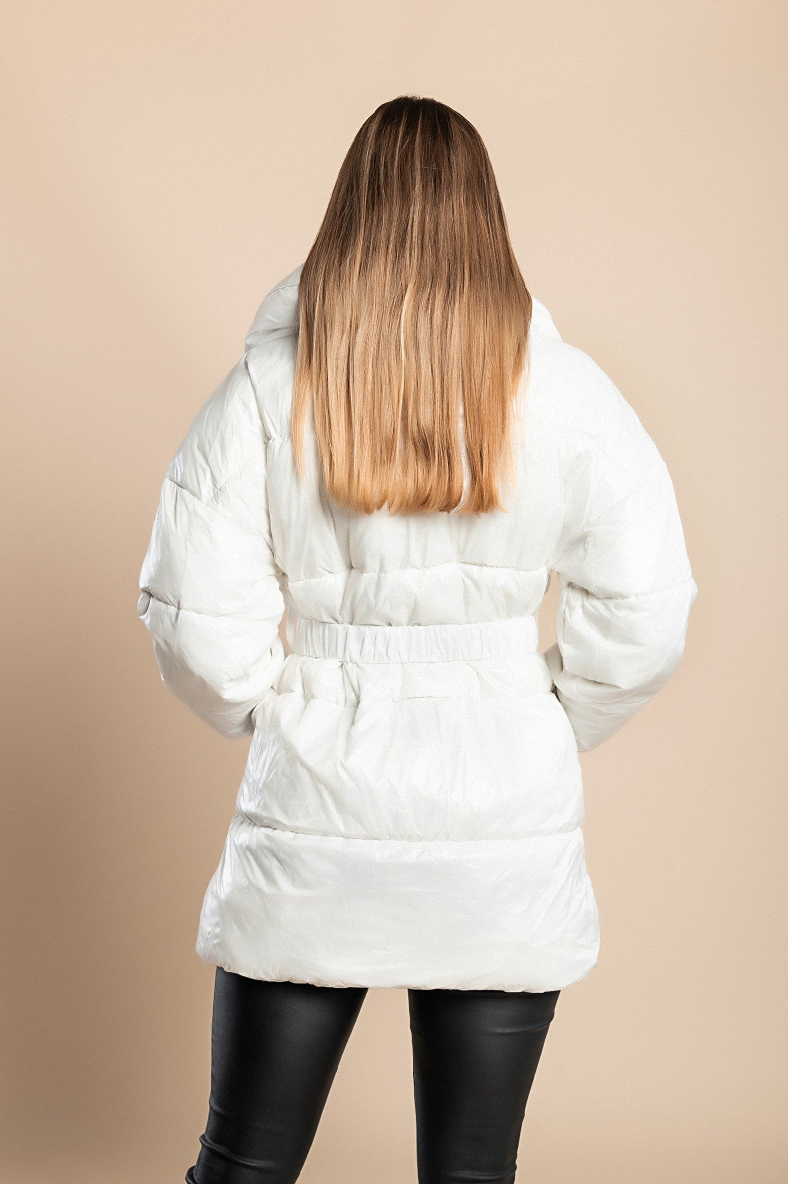 Long padded white jacket with high collar and elastic waist, featuring a zip closure and warm filling.