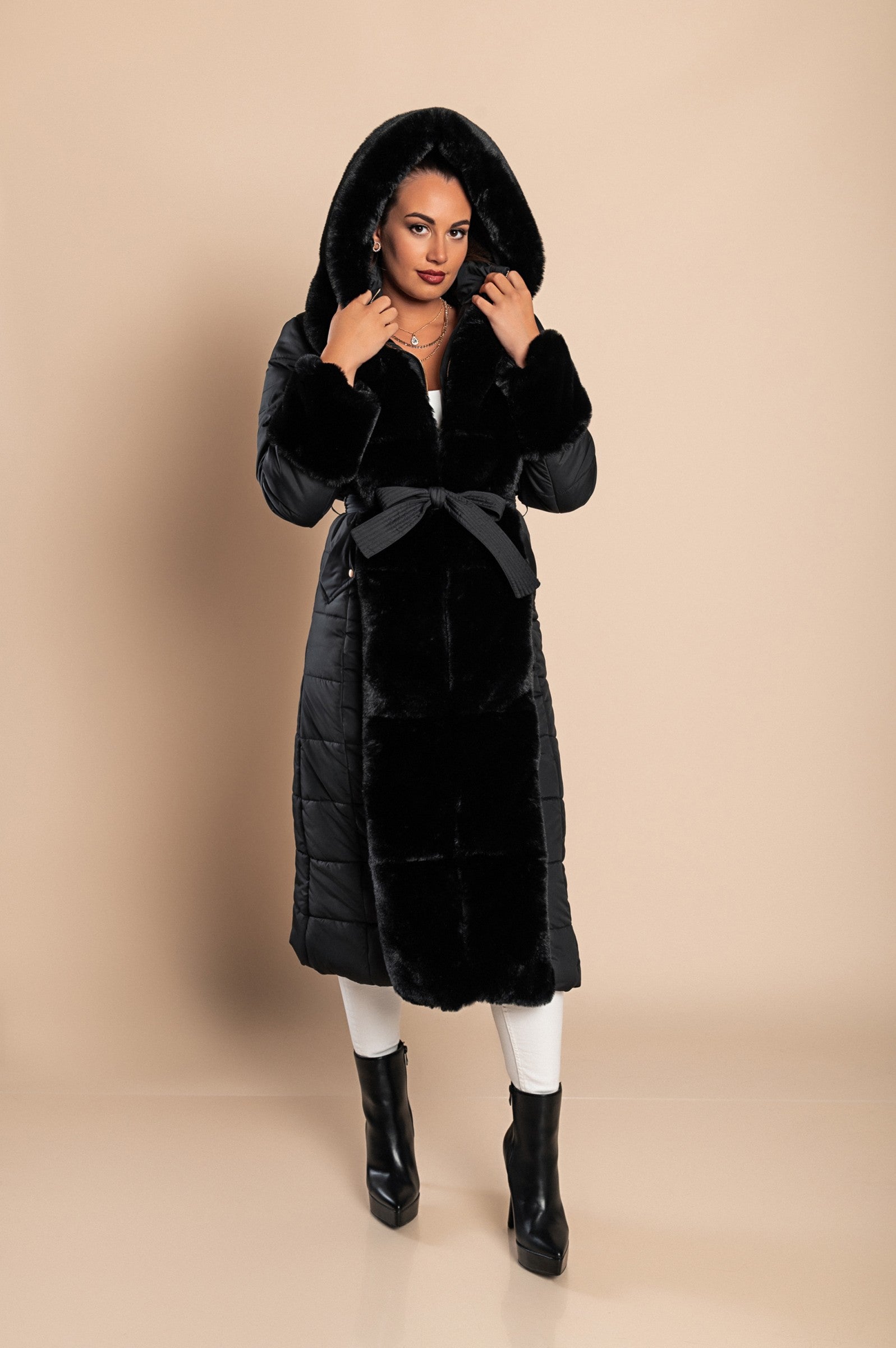 Long padded winter jacket in black with removable faux fur trim, side pockets, and metal zipper closure.