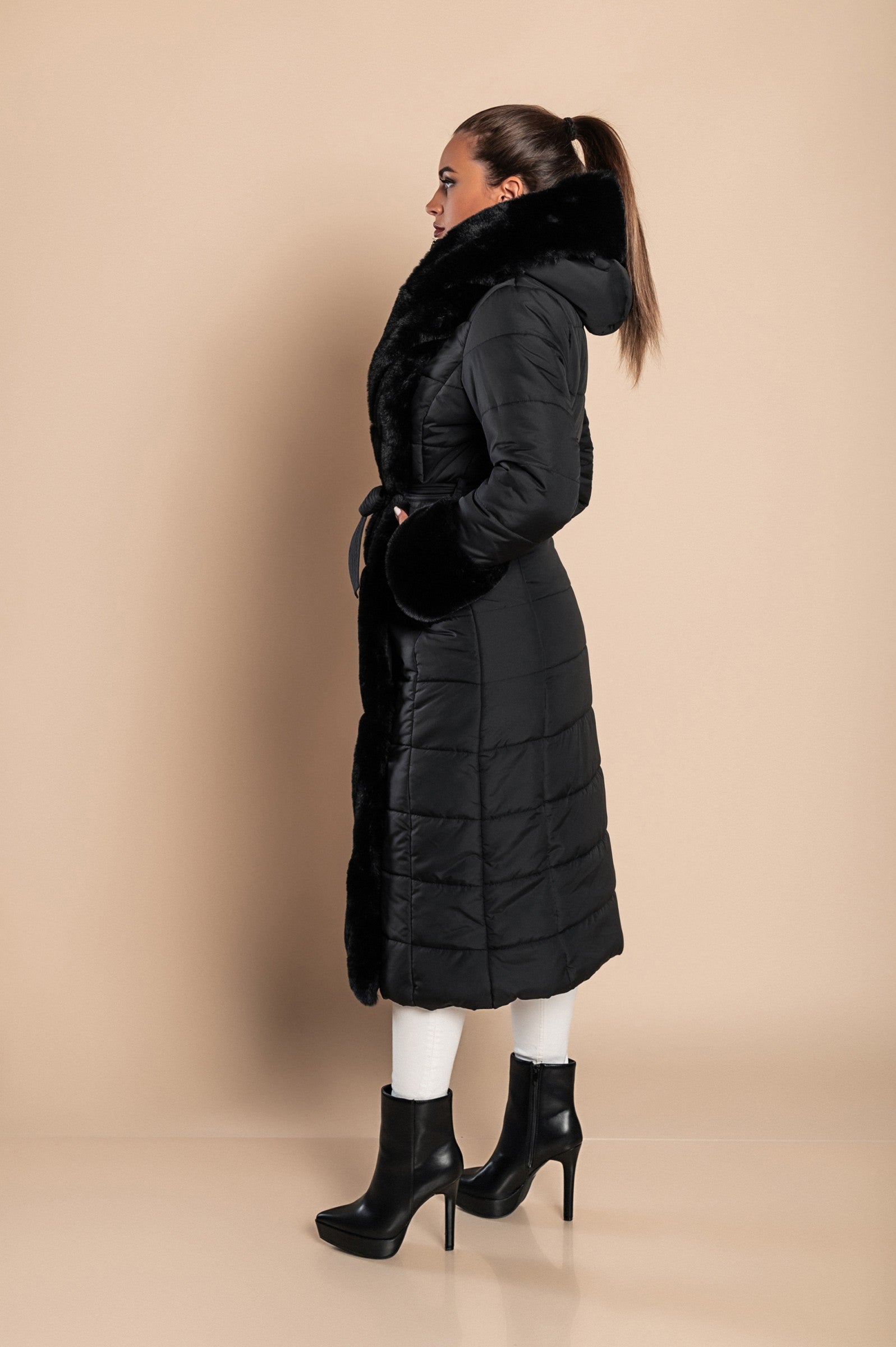 Long padded winter jacket in black with removable faux fur trim, side pockets, and metal zipper closure.