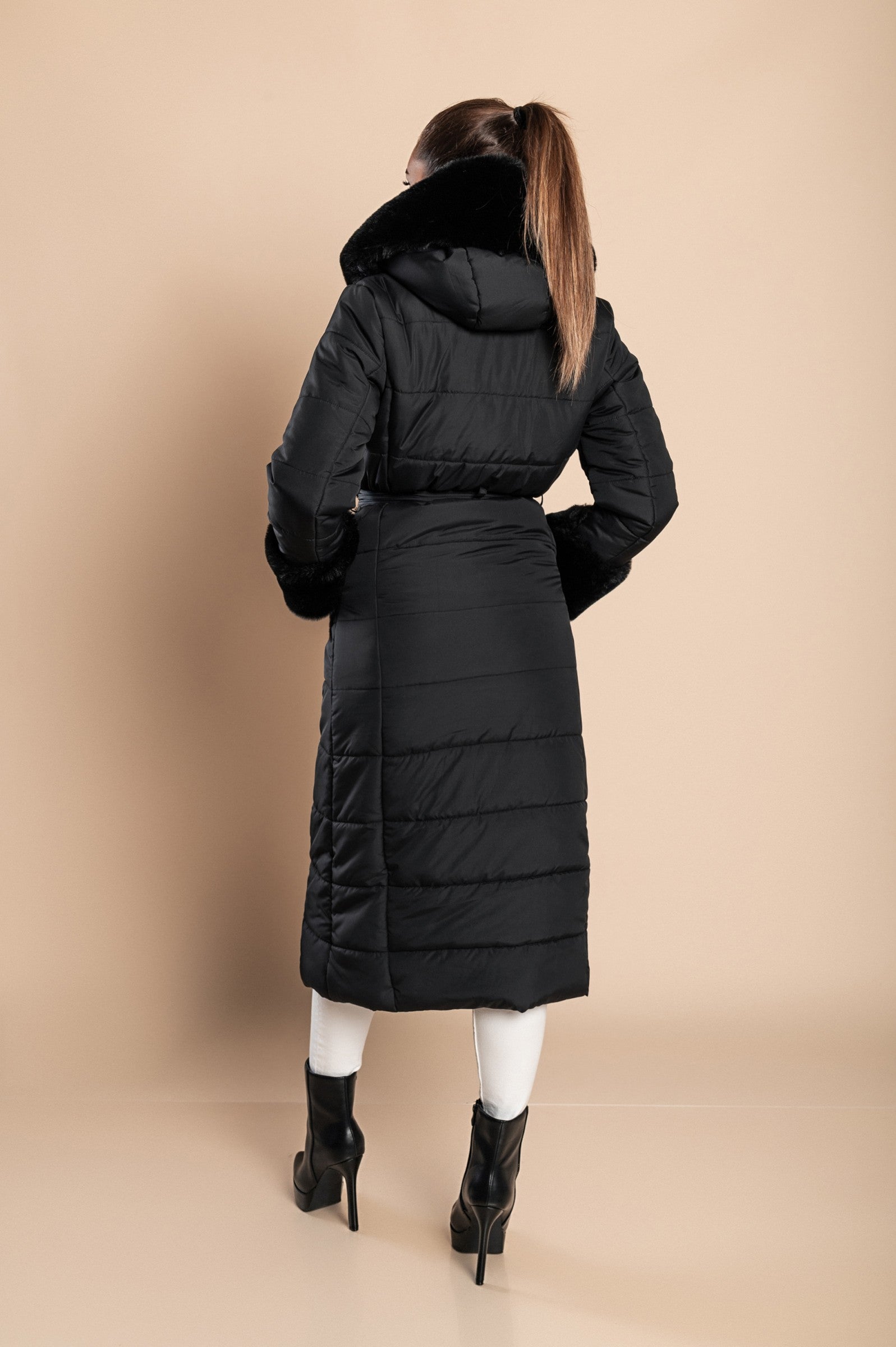 Long padded winter jacket in black with removable faux fur trim, side pockets, and metal zipper closure.