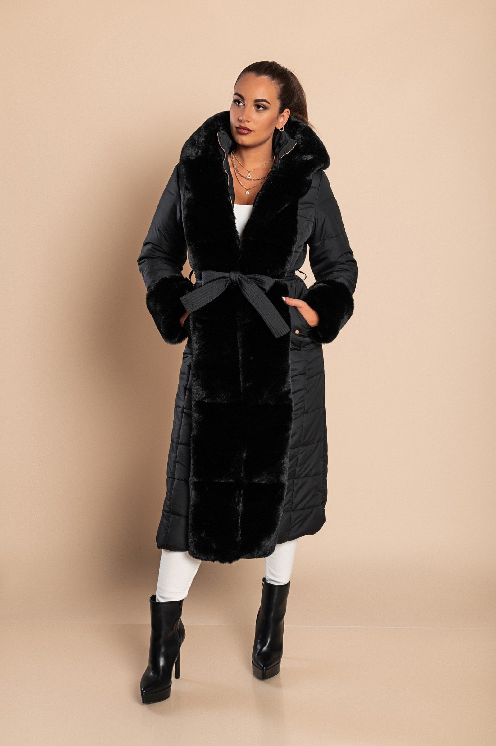 Long padded winter jacket in black with removable faux fur trim, side pockets, and metal zipper closure.