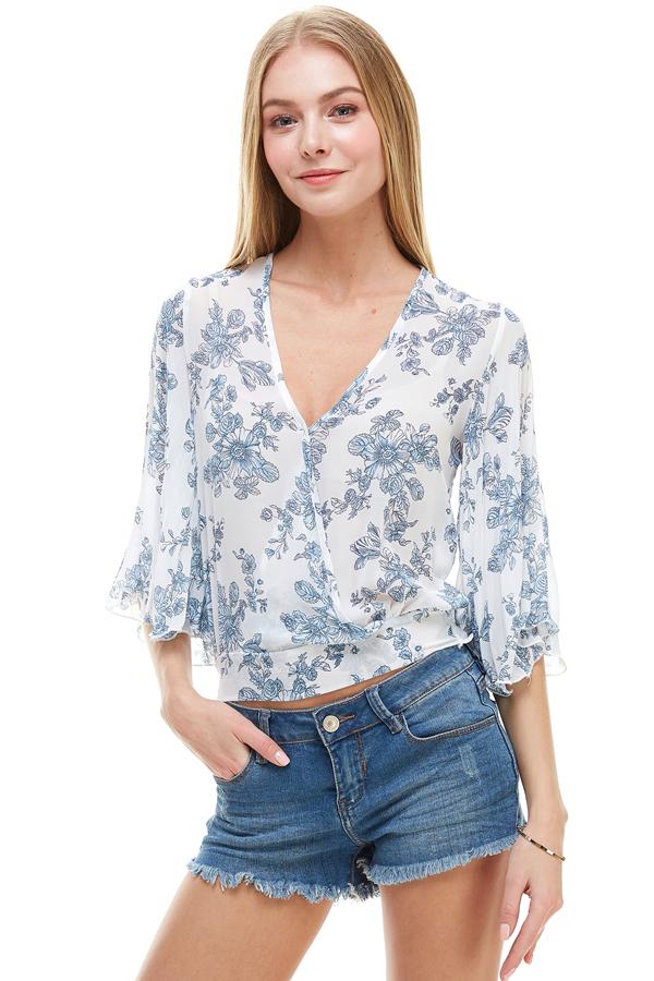 A stylish long sleeve surplice floral top featuring a deep V neckline and tie back design, perfect for casual and formal occasions.