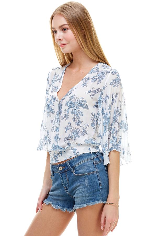 A stylish long sleeve surplice floral top featuring a deep V neckline and tie back design, perfect for casual and formal occasions.