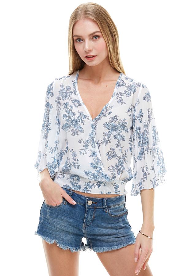 A stylish long sleeve surplice floral top featuring a deep V neckline and tie back design, perfect for casual and formal occasions.