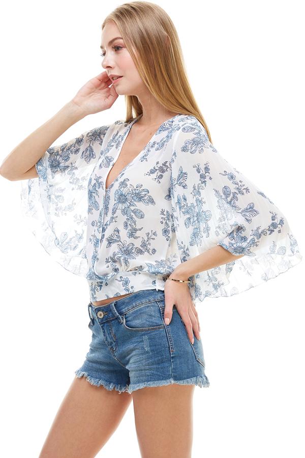 A stylish long sleeve surplice floral top featuring a deep V neckline and tie back design, perfect for casual and formal occasions.