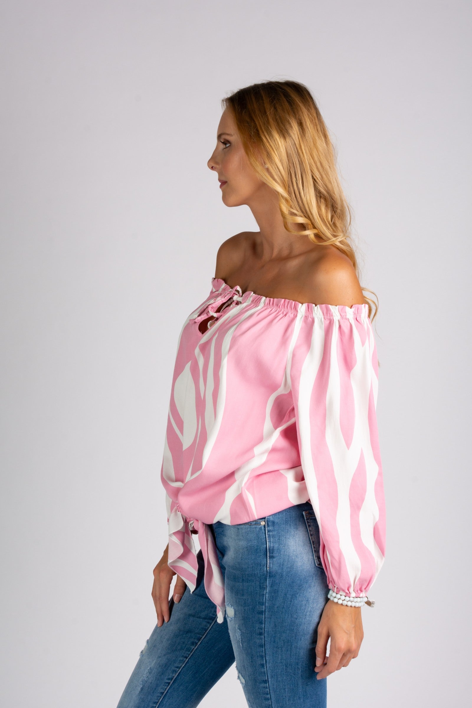 Loose blouse with open shoulders, featuring elastic sleeves and a drawstring tie at the bottom, made of high-quality viscose.