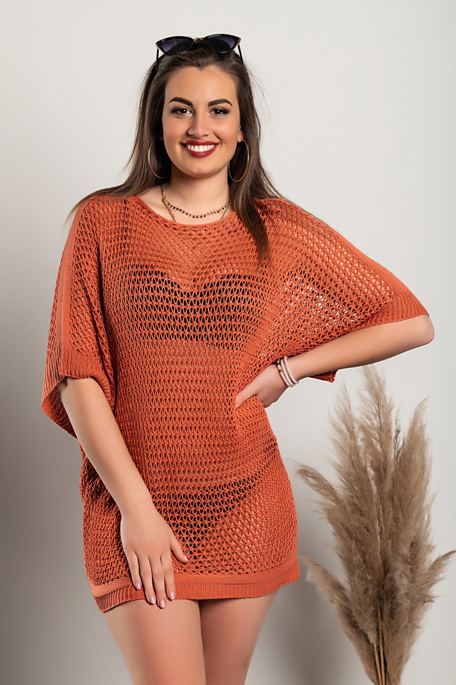 A stylish coral loose knit tunic featuring a boat neckline and short sleeves, perfect for casual wear.