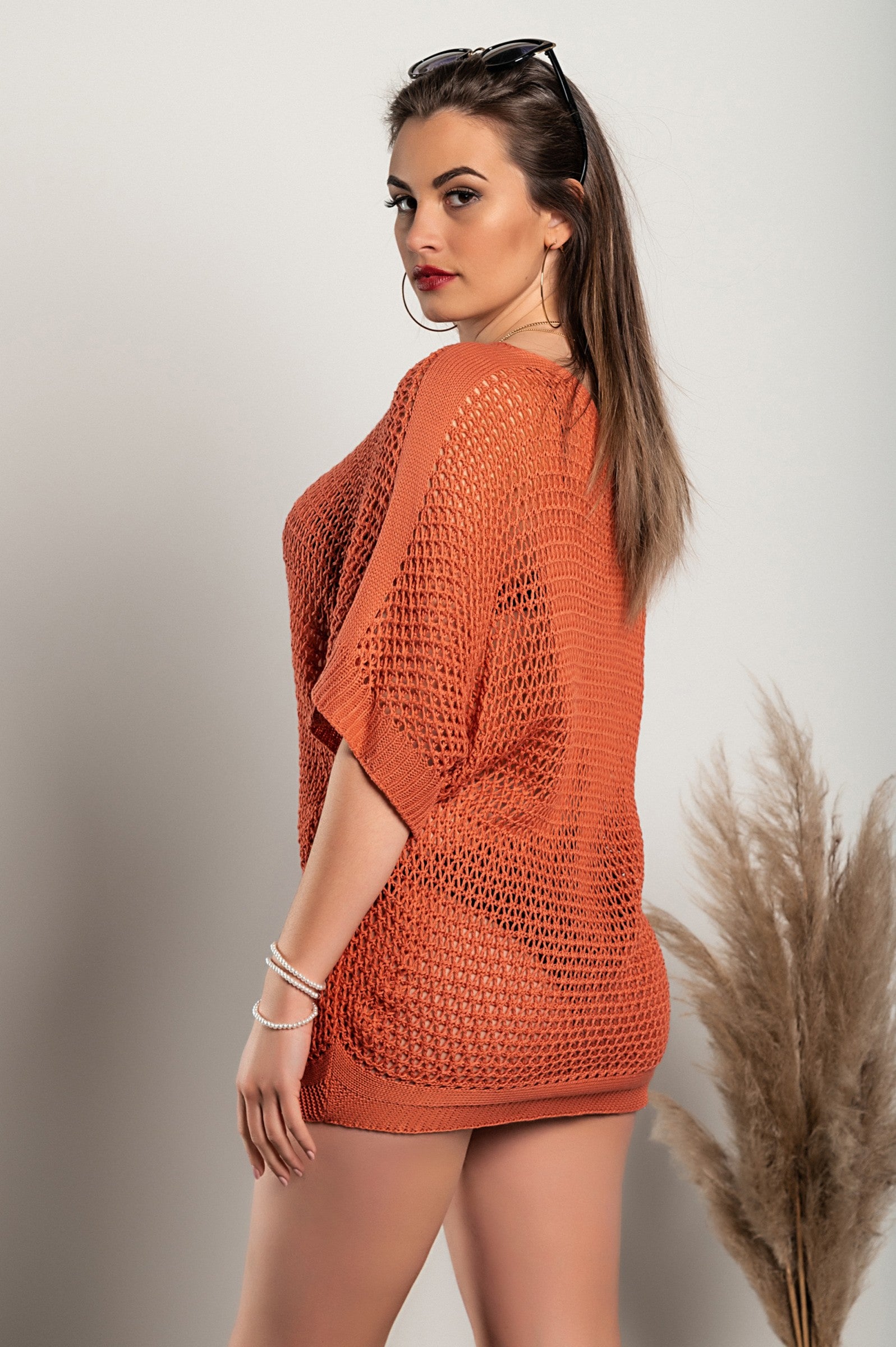 A stylish coral loose knit tunic featuring a boat neckline and short sleeves, perfect for casual wear.