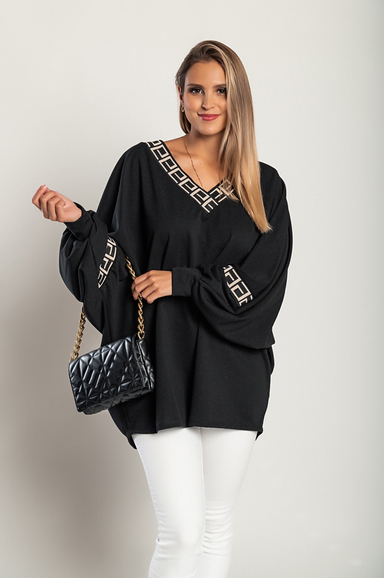 Loose black top featuring a geometric print, deep V-neckline, and long sleeves, designed for comfort and style.