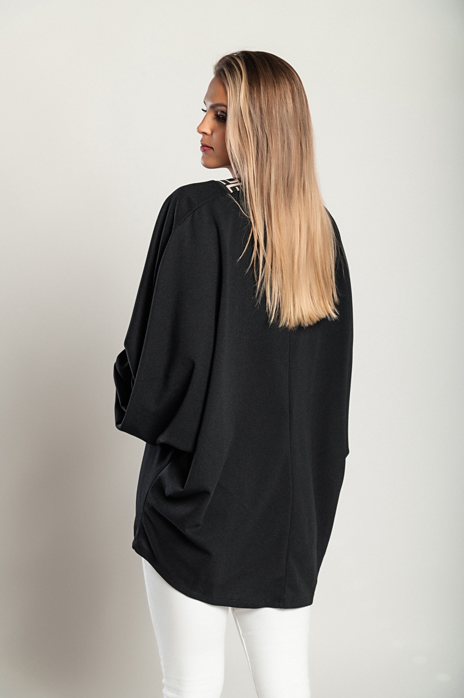 Loose black top featuring a geometric print, deep V-neckline, and long sleeves, designed for comfort and style.