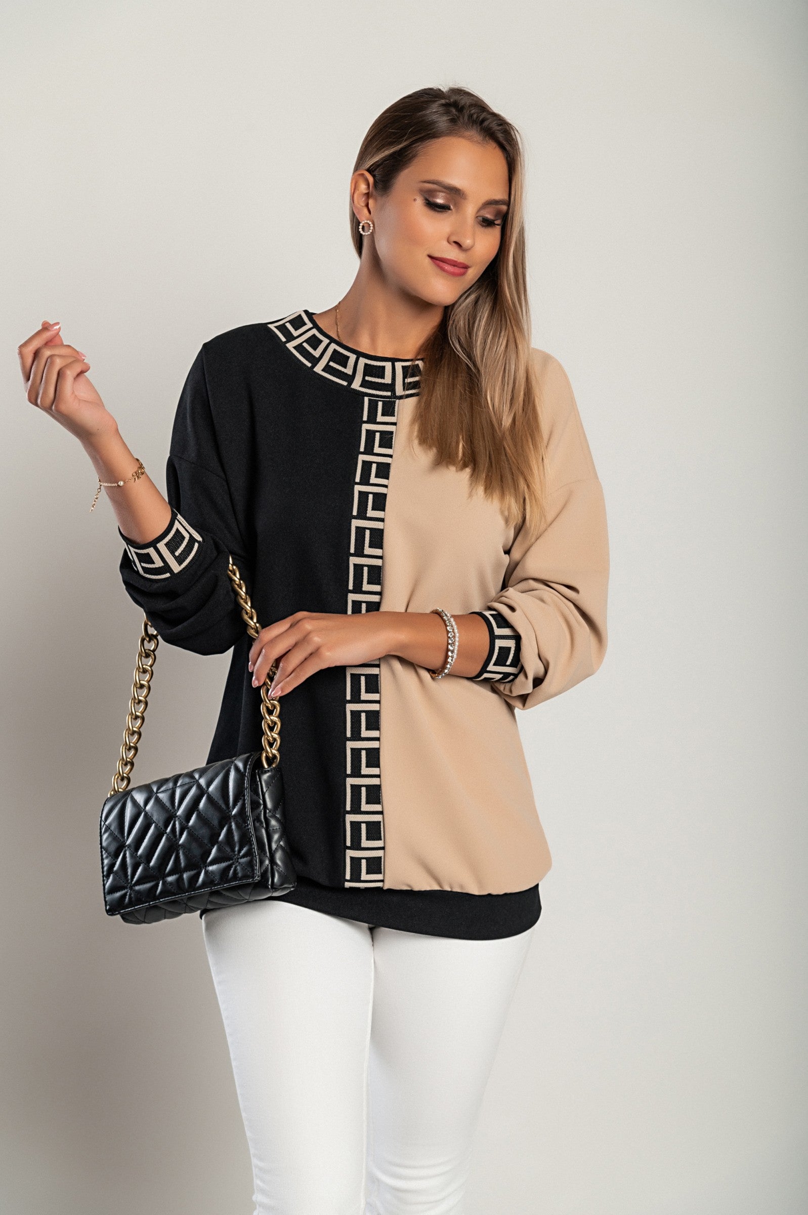 Loose top featuring a geometric print in black and beige, showcasing a round neckline and long sleeves, designed for comfort and style.