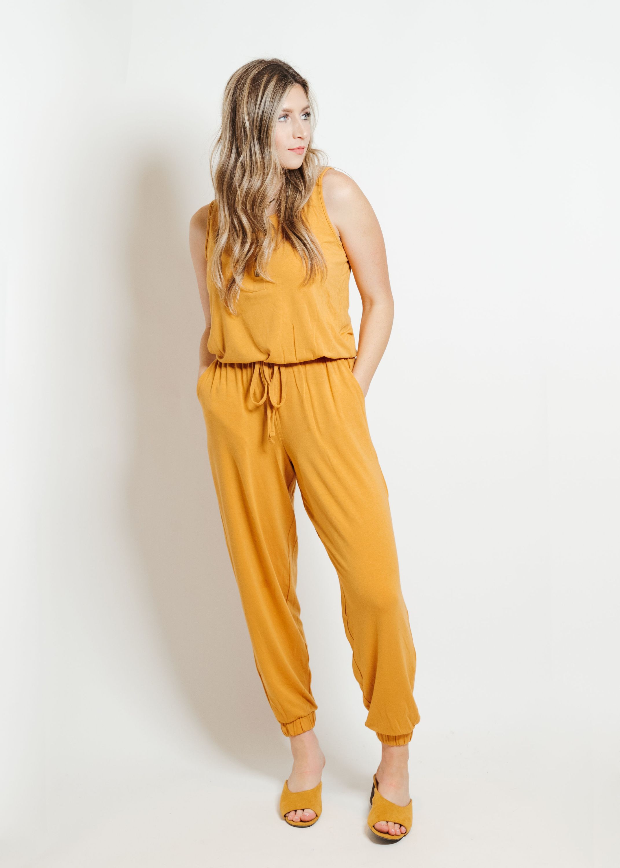 A stylish mustard-colored lounge jumpsuit displayed on a mannequin, showcasing its comfortable fit and trendy design.