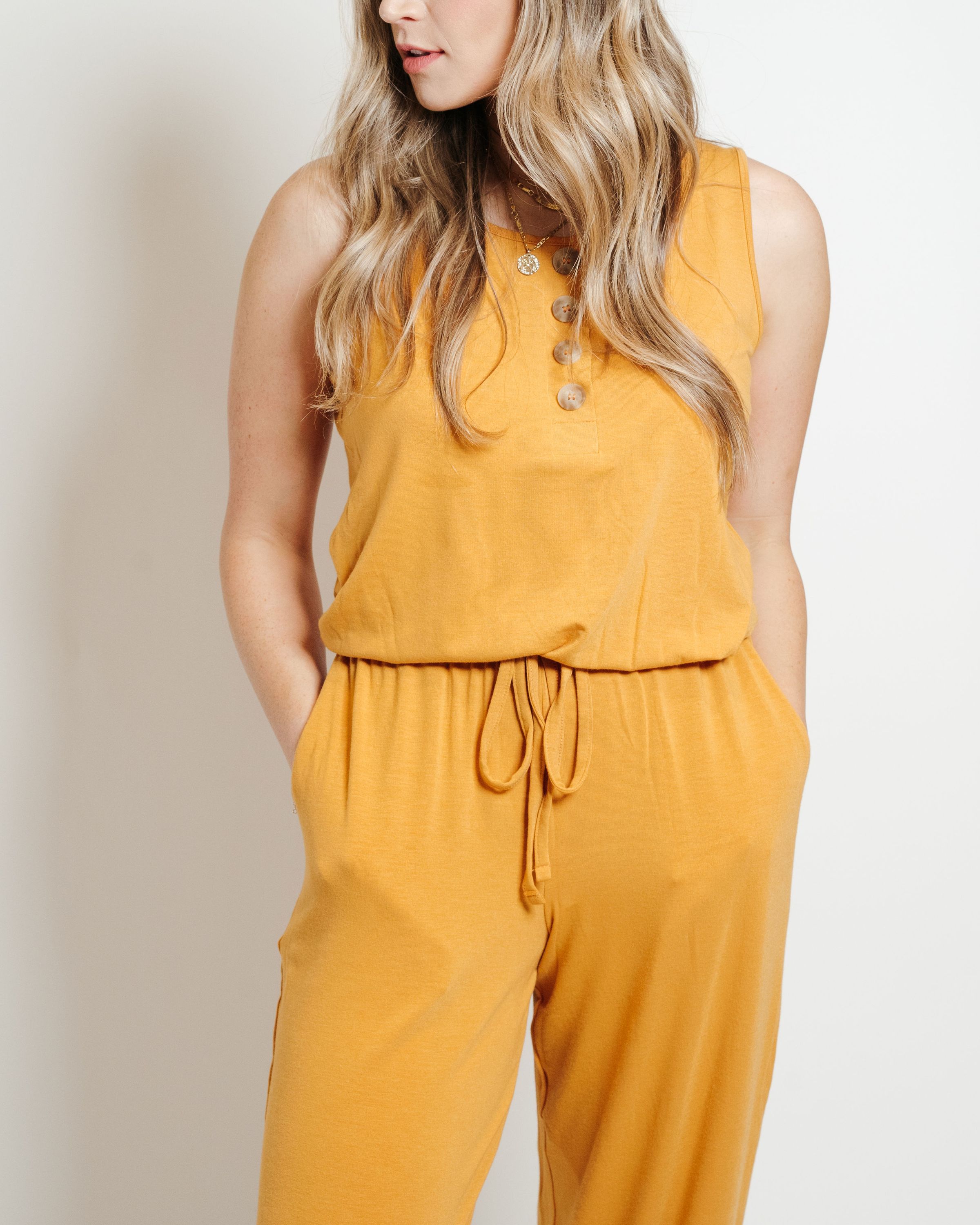 A stylish mustard-colored lounge jumpsuit displayed on a mannequin, showcasing its comfortable fit and trendy design.