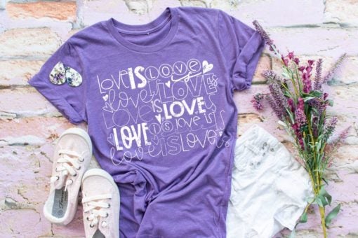 Love is Love Pride Tee featuring a white design, available in various styles and sizes, perfect for celebrating LGBTQ+ pride.