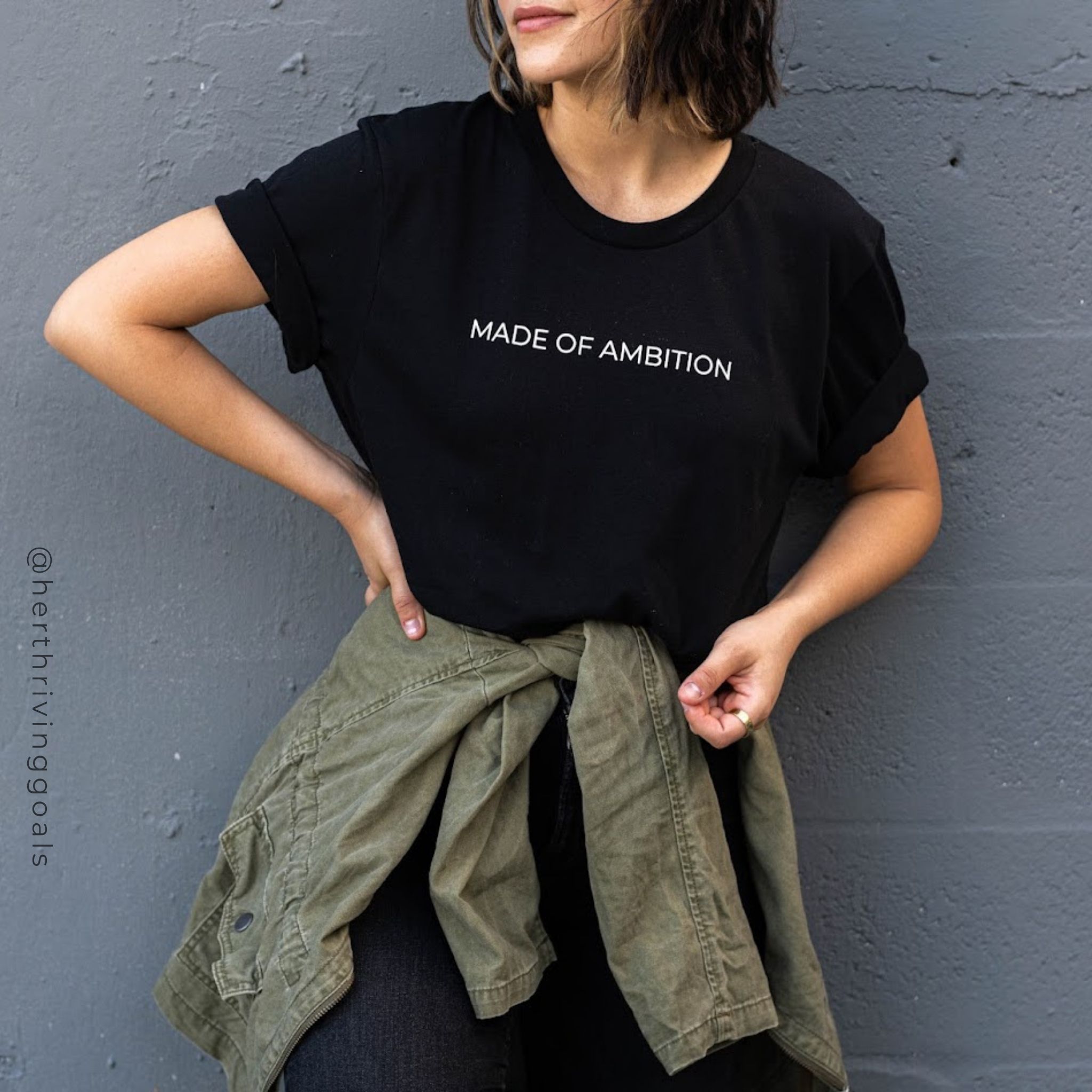 A stylish unisex MADE OF AMBITION TEE shirt displayed on a hanger, showcasing its comfortable fit and motivational design.