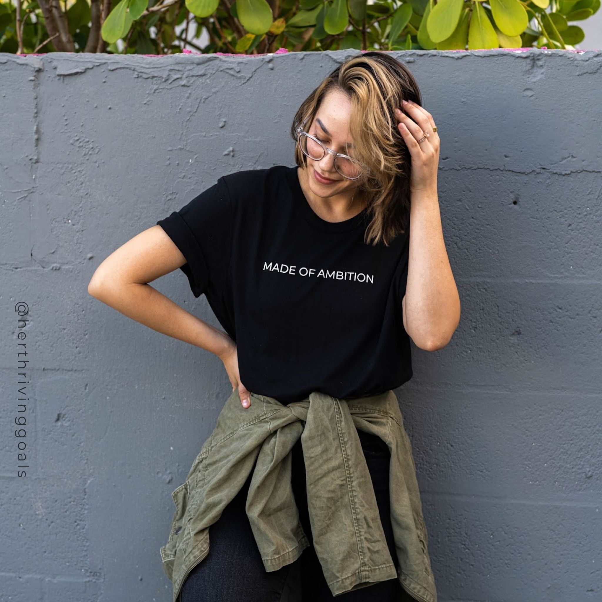 A stylish unisex MADE OF AMBITION TEE shirt displayed on a hanger, showcasing its comfortable fit and motivational design.