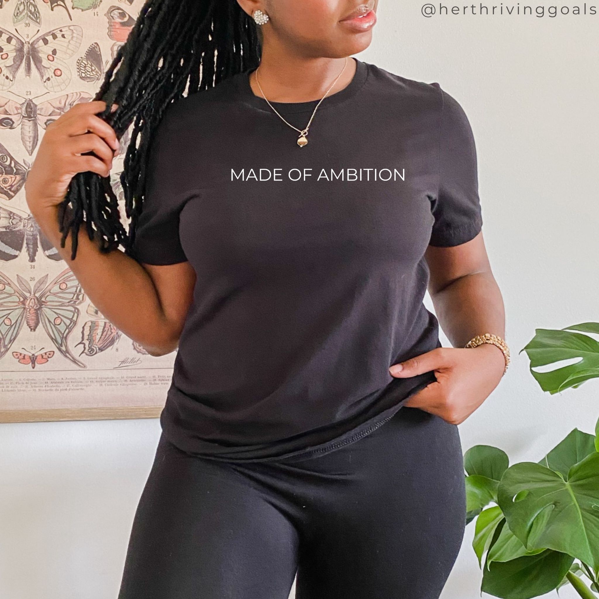 A stylish unisex MADE OF AMBITION TEE shirt displayed on a hanger, showcasing its comfortable fit and motivational design.