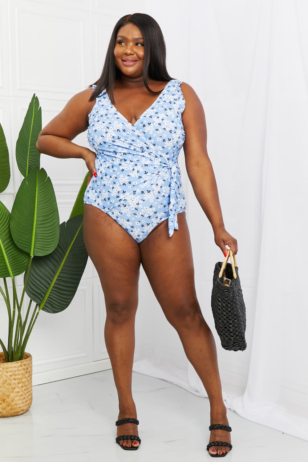 Marina West Swim Full Size Float On Ruffle Faux Wrap One-Piece featuring floral pattern and frilly straps, perfect for beach outings.