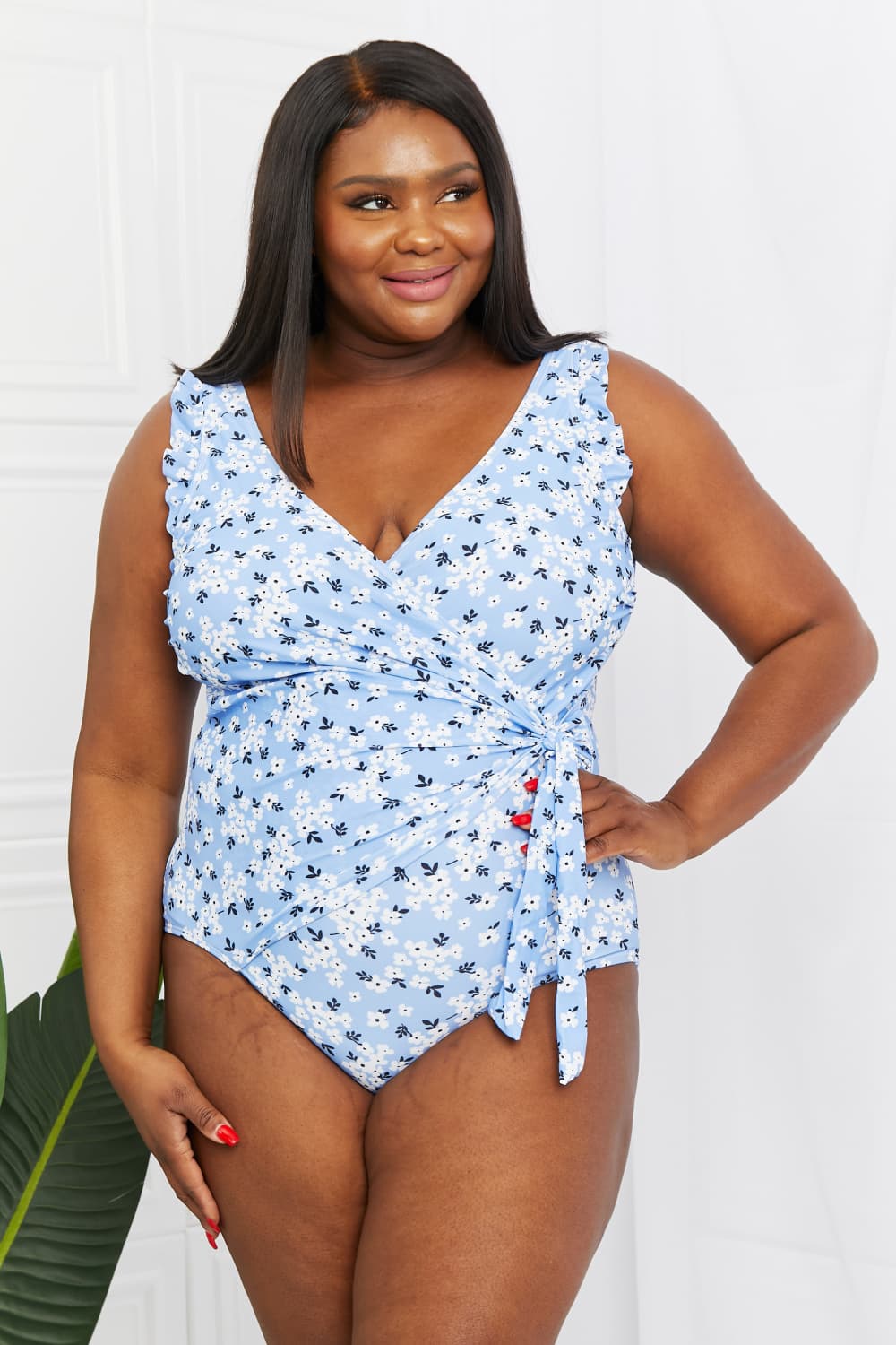 Marina West Swim Full Size Float On Ruffle Faux Wrap One-Piece featuring floral pattern and frilly straps, perfect for beach outings.