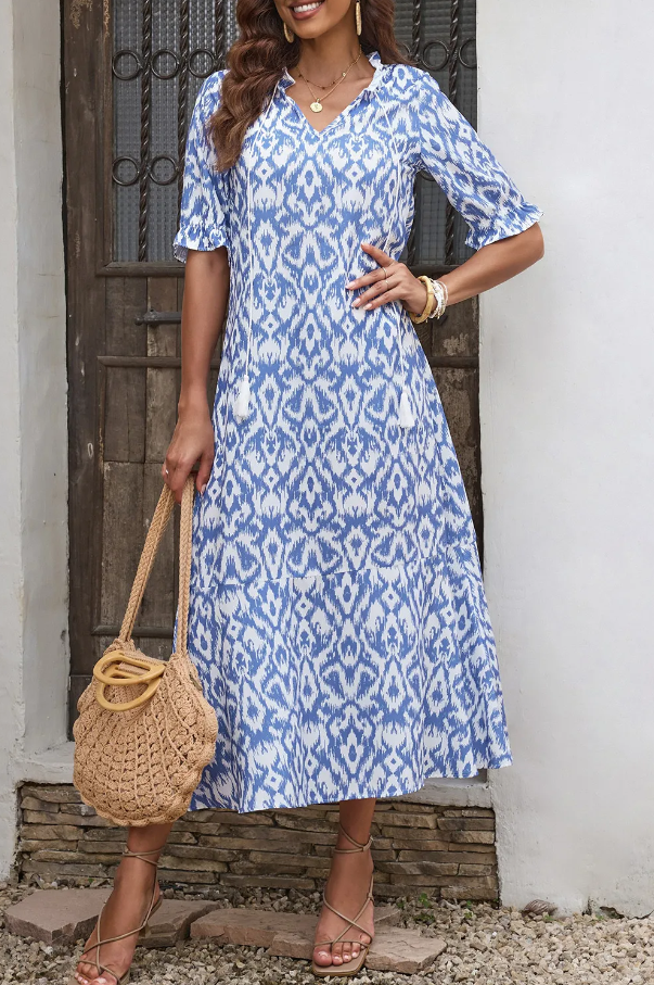 Light blue maxi dress featuring a geometric print, V-neckline, and frilly short sleeves, perfect for summer occasions.