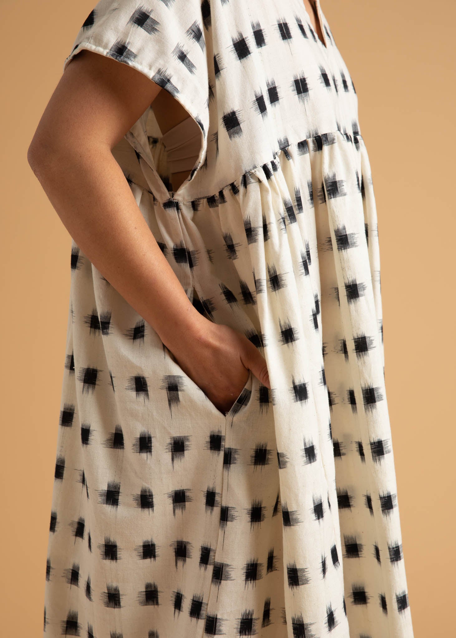 The Meadow Dress in Ikat Squares pattern, showcasing its flowy design, semi V-neck, and hidden side pockets.