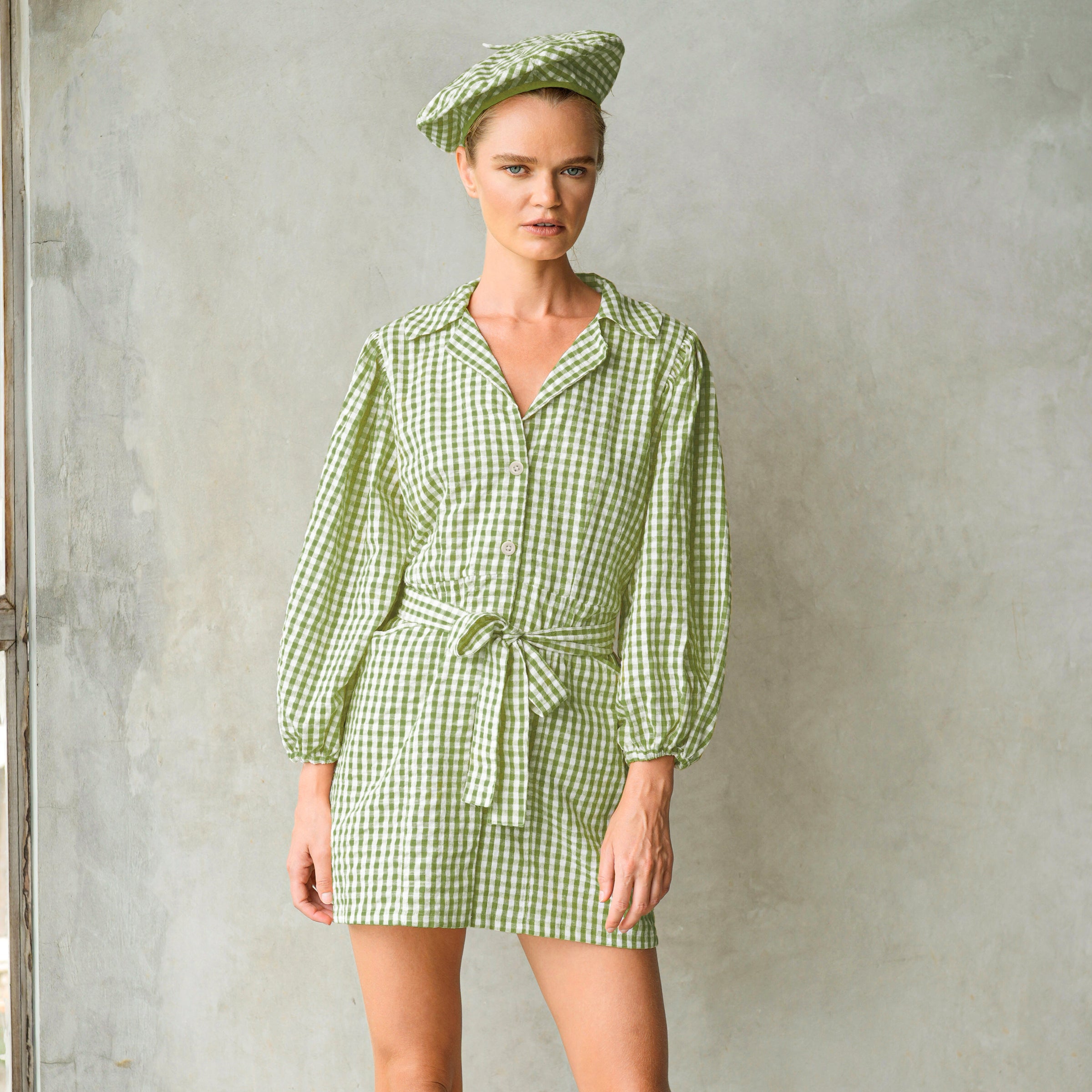 Olive green Meghan mini gingham dress featuring puff sleeves and a removable waist belt, perfect for casual outings.