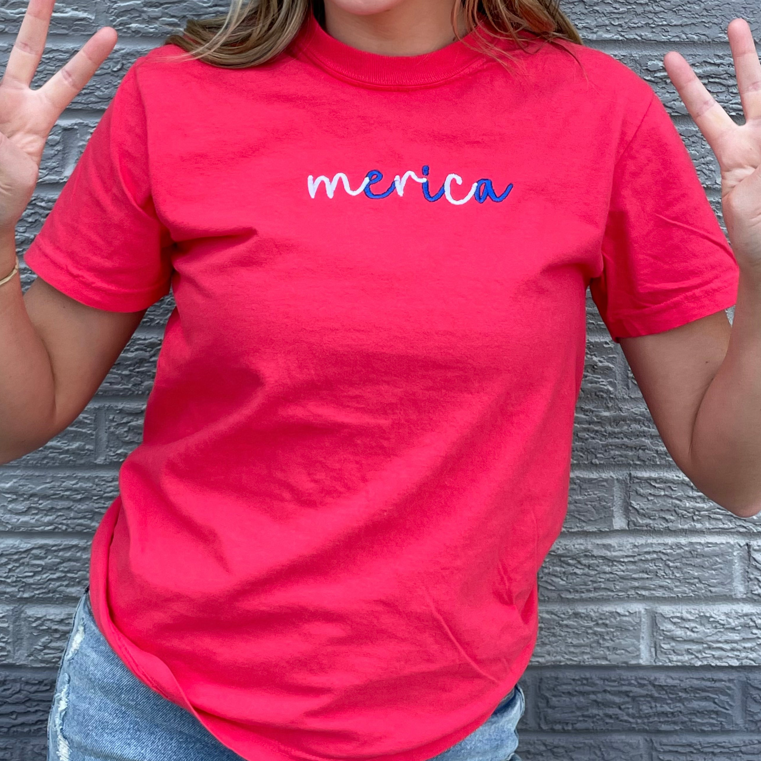 Merica Embroidered Tee in Paprika color, showcasing a bold patriotic design with comfortable fit.