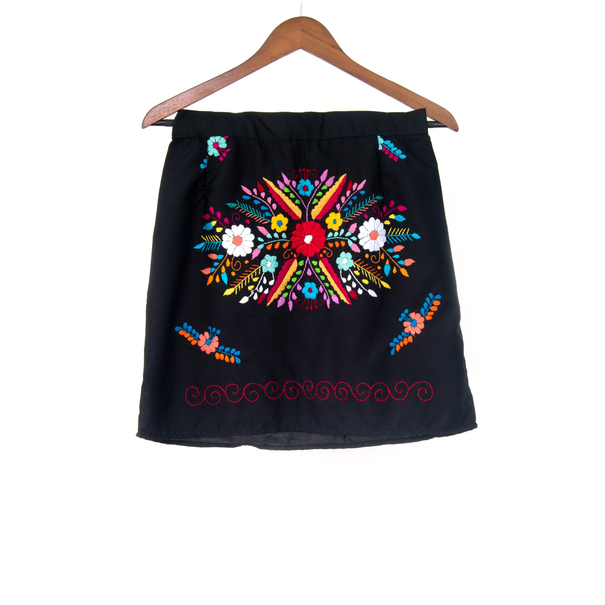 A vibrant Mexican embroidered mini skirt featuring multicolor floral designs on a black background, showcasing unique artisan craftsmanship.