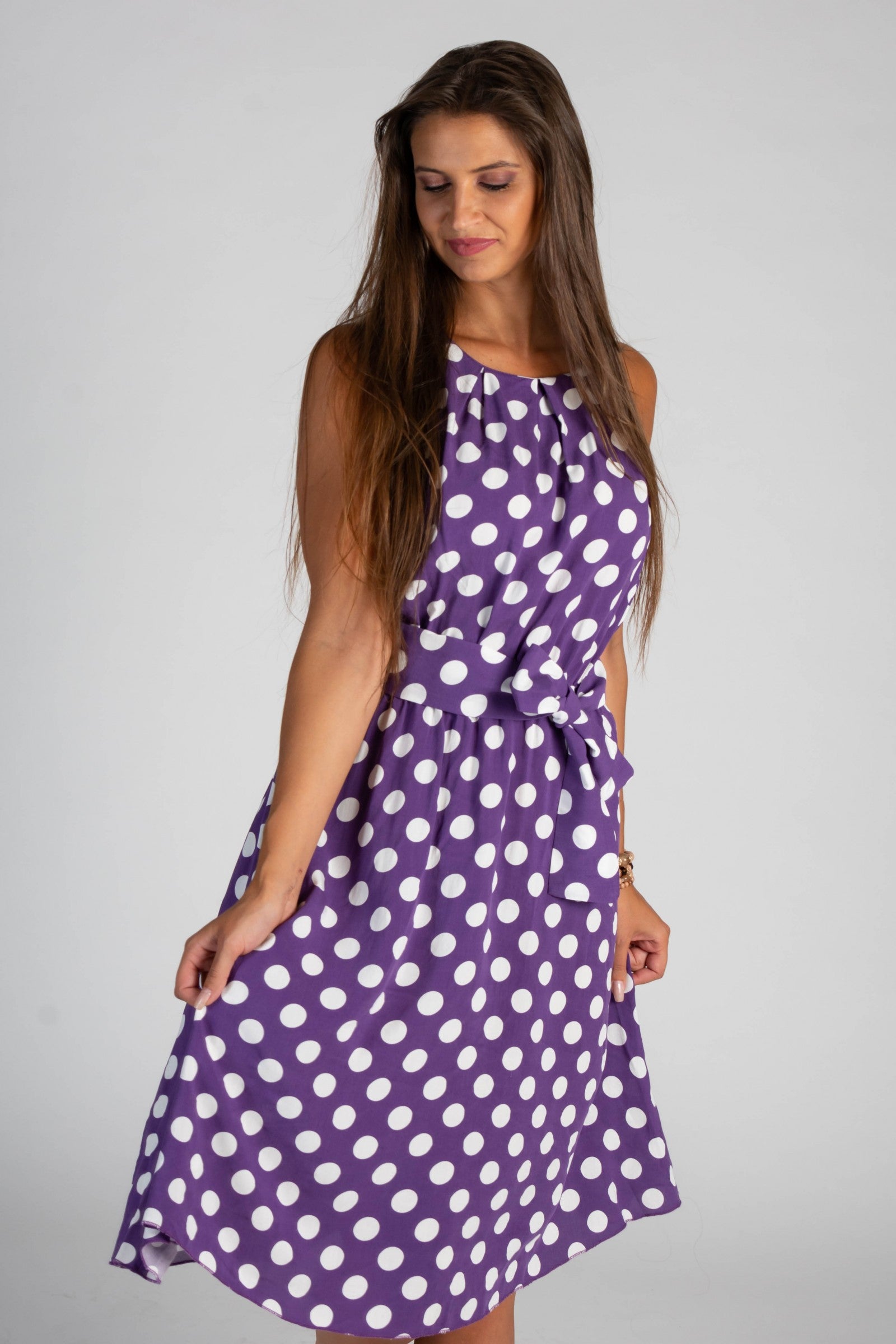 Lilac midi dress with a playful dot print, featuring a round collar, sleeveless design, and a decorative waist tie.